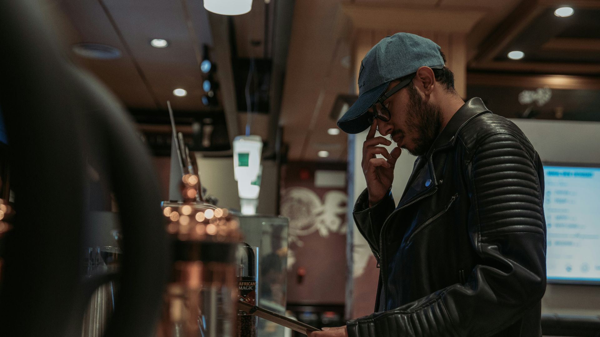 a man in a leather jacket talking on a cell phone