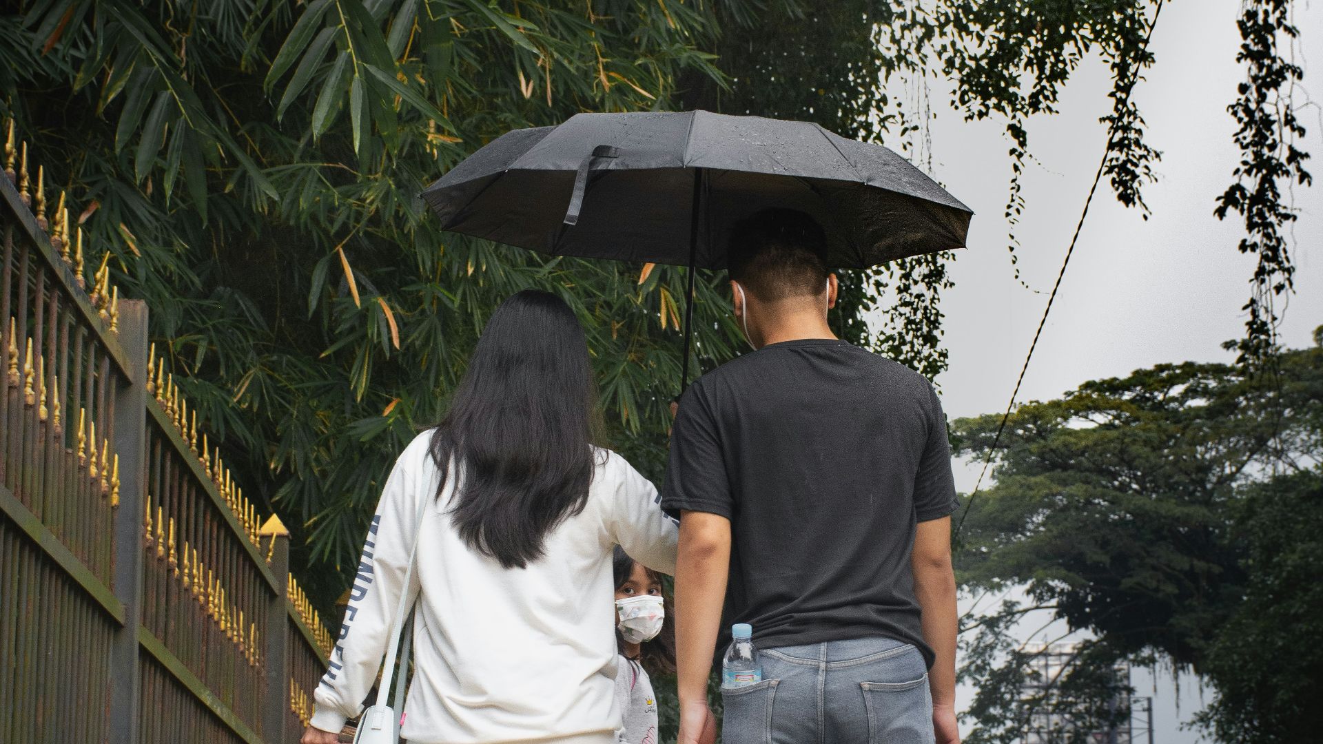 a man and a woman walking under an umbrella