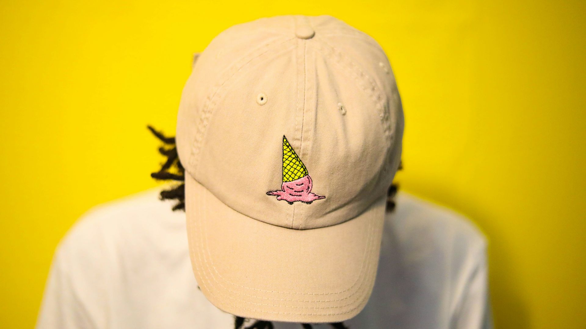 man wearing gray cap looking down