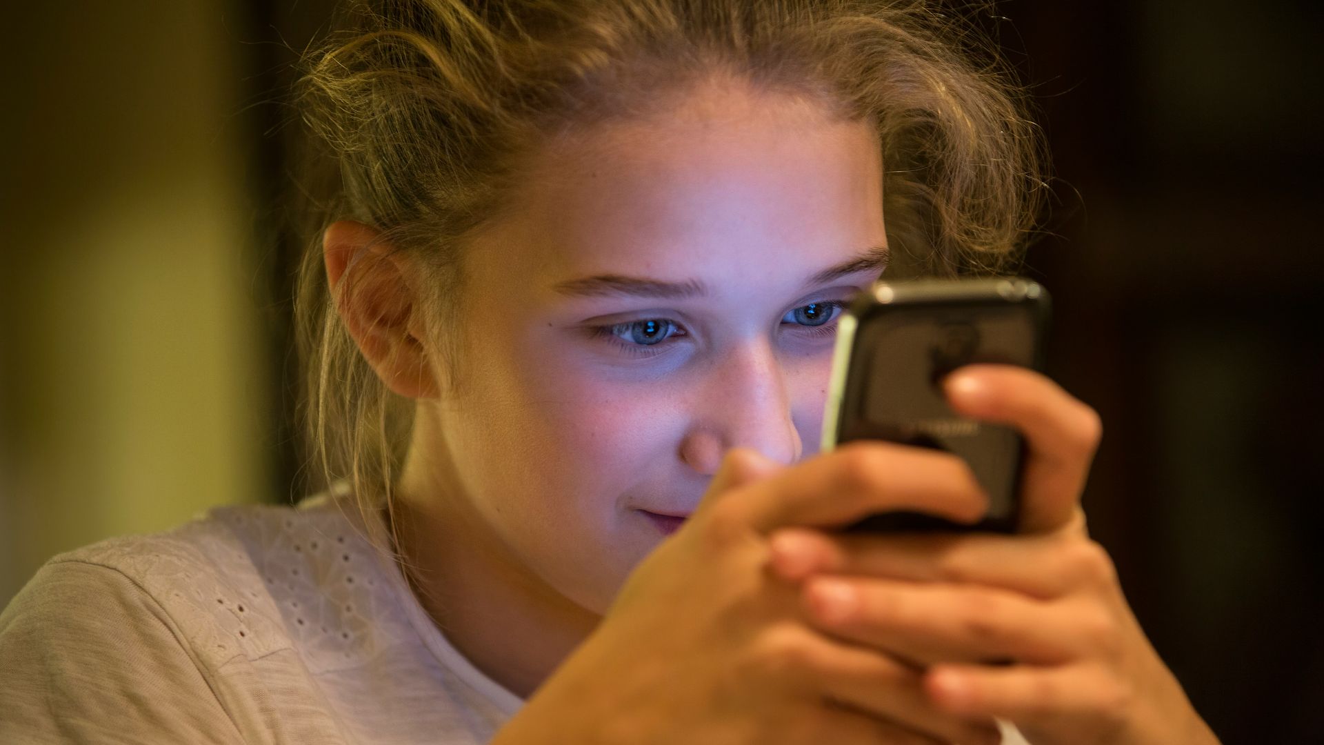 woman in gray top using smartphone