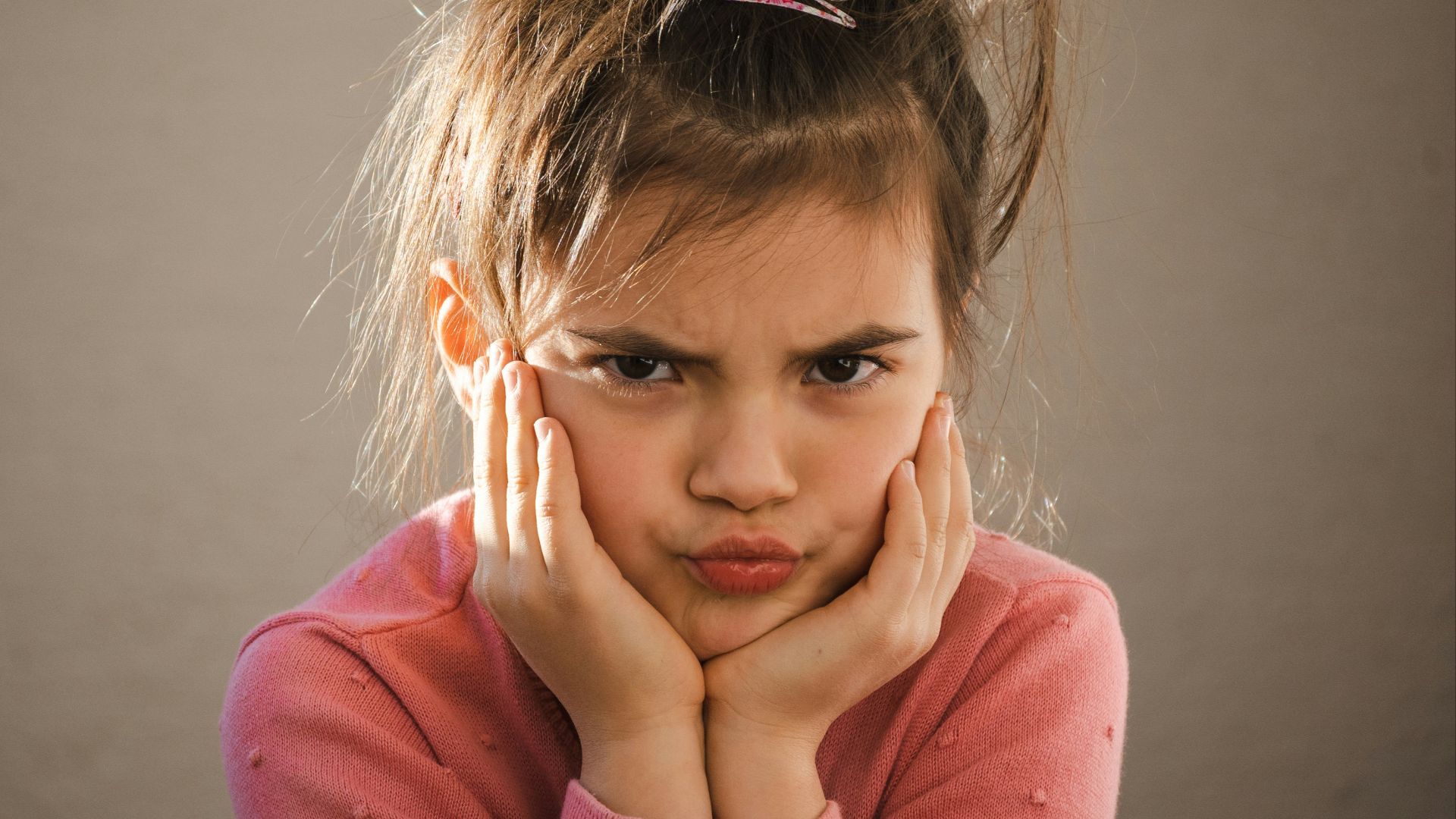 a young girl with her hands on her face