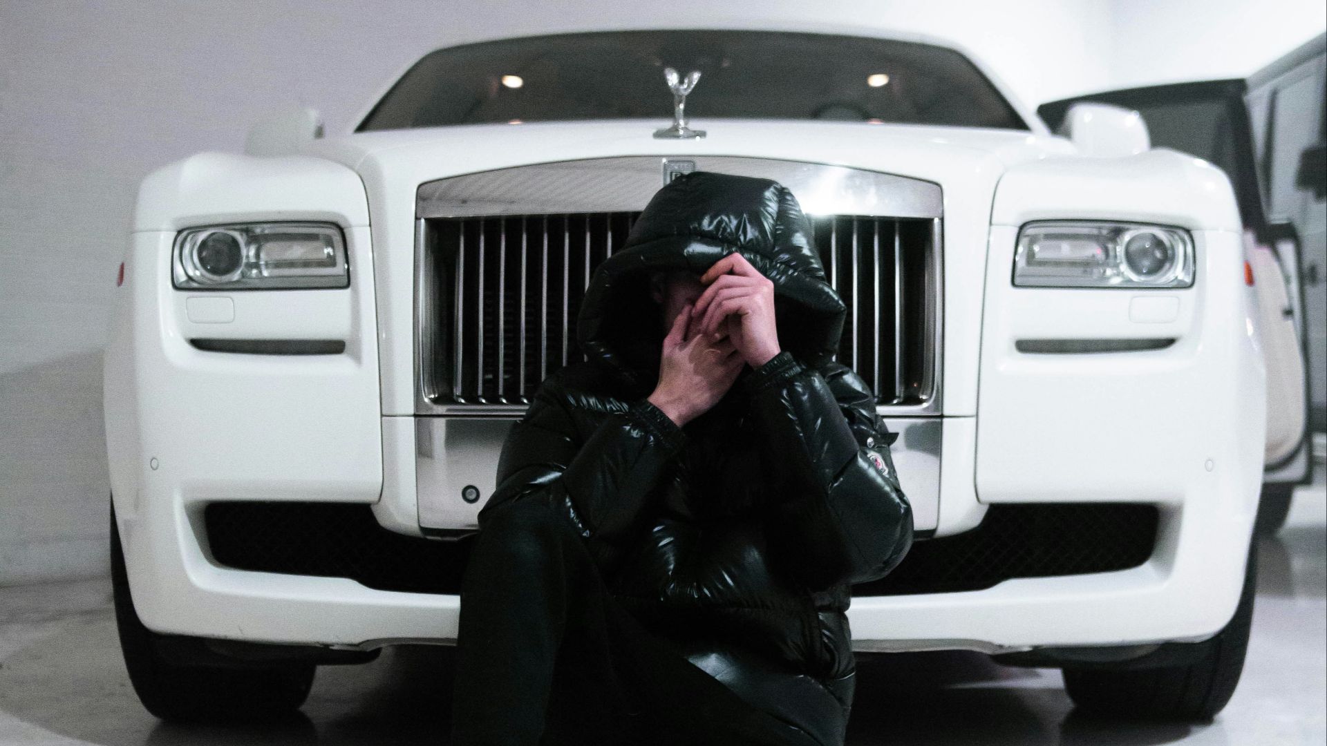 woman in black jacket and black pants sitting on white car