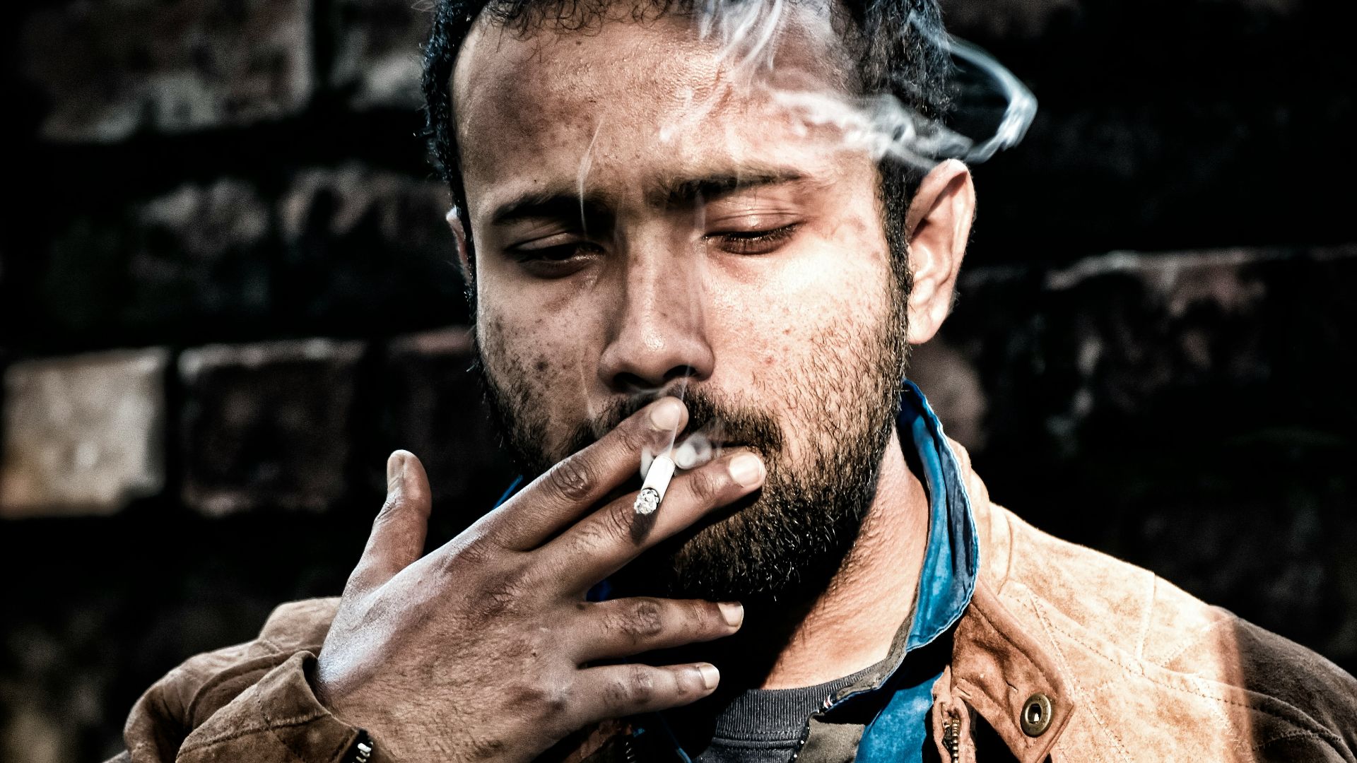 man in brown leather jacket smoking