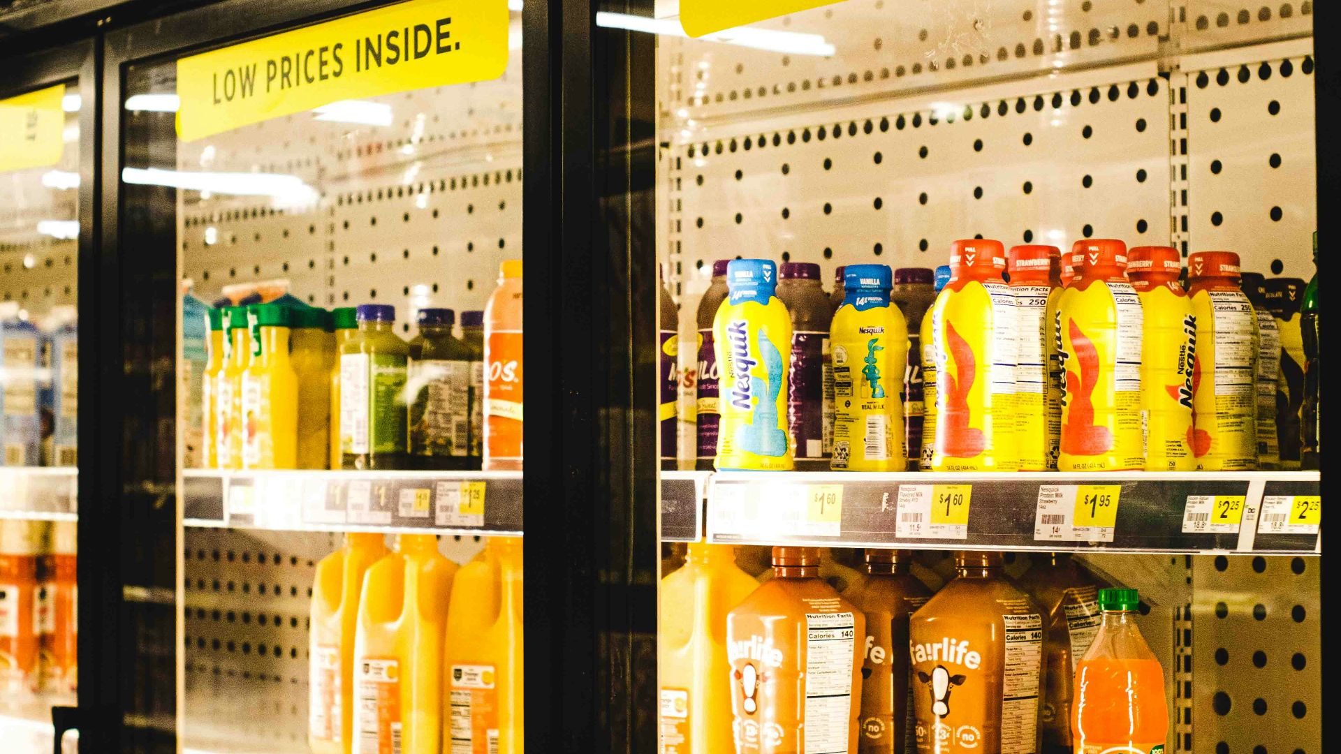 a display case in a grocery store filled with orange juice