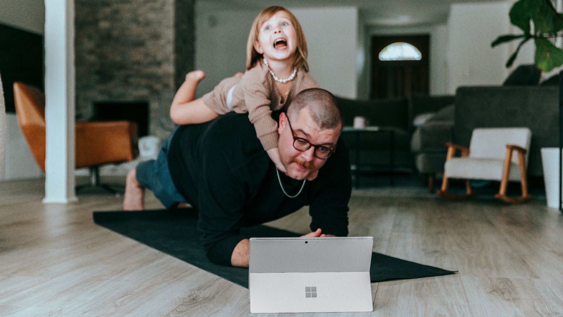 a man and a little girl playing with a laptop