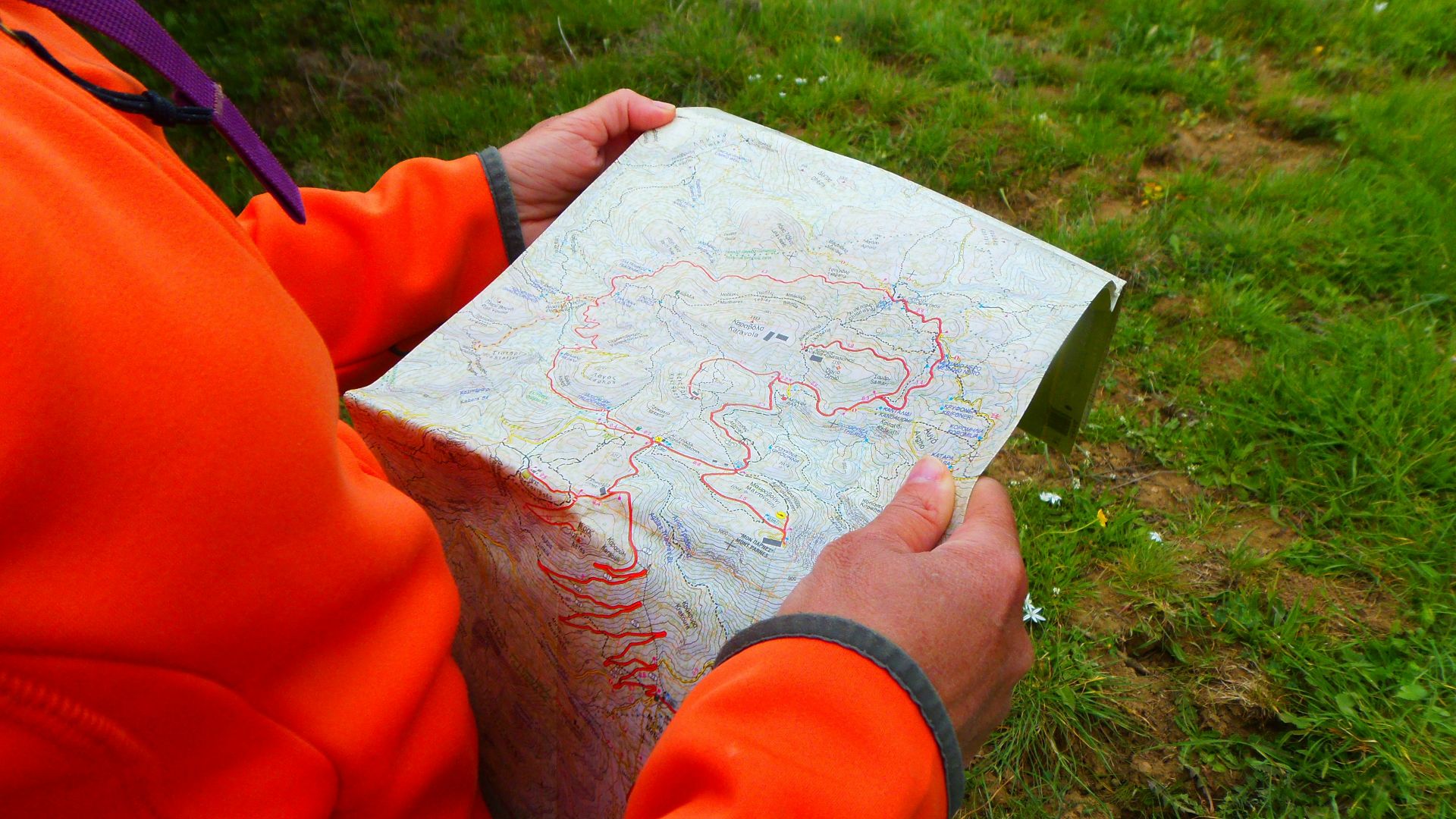 person in orange long sleeve shirt holding white printer paper