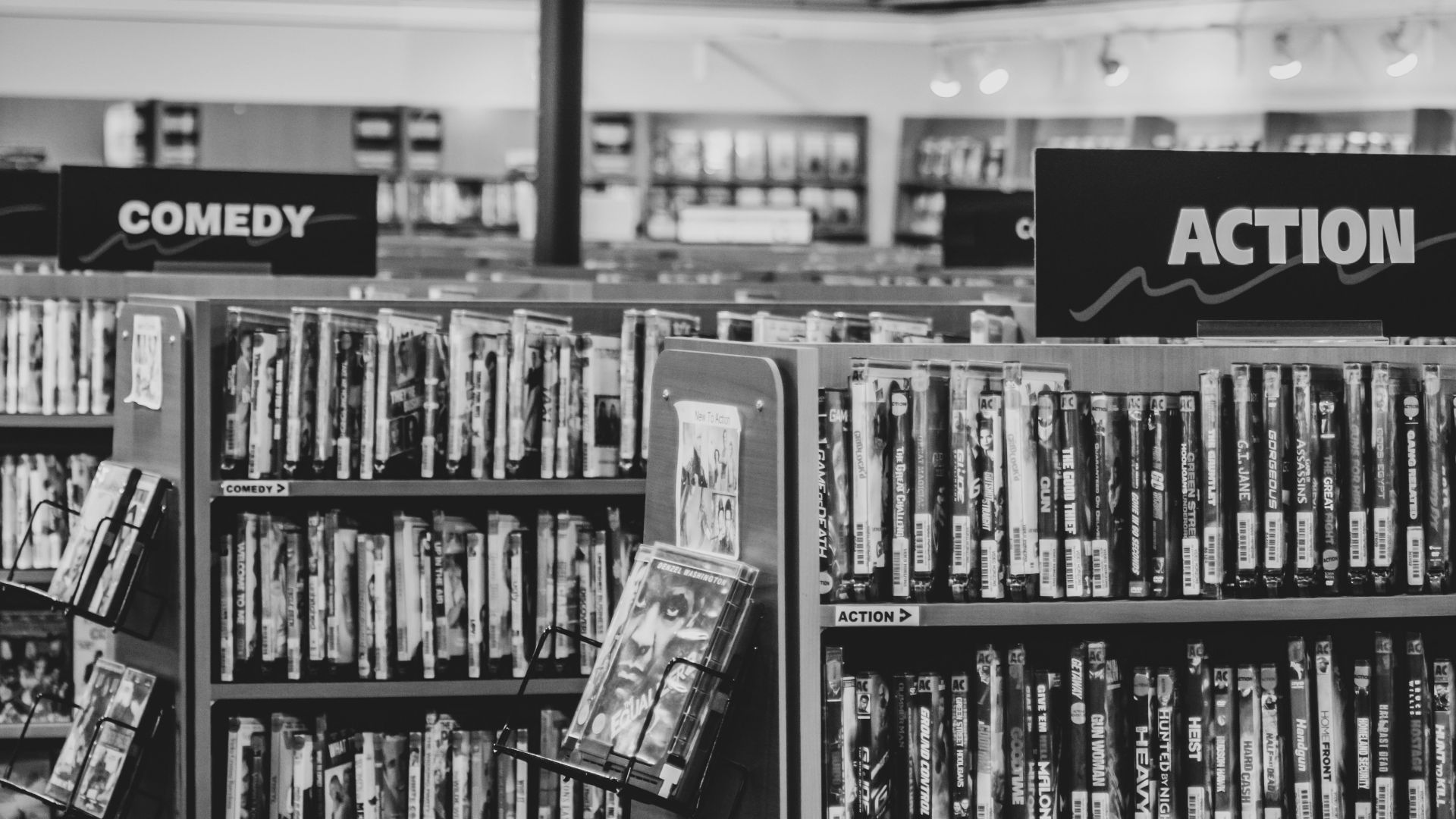 grayscale photo of books on shelves