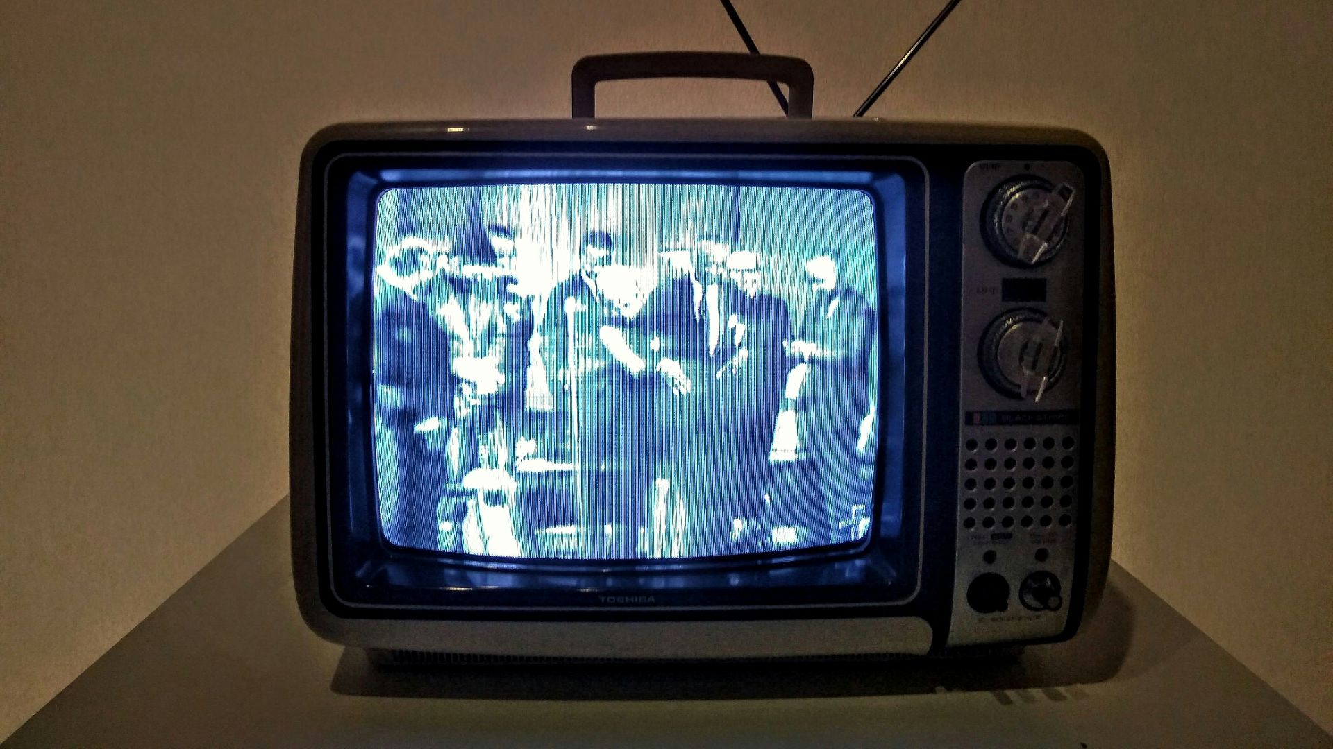 black crt tv turned on on white table