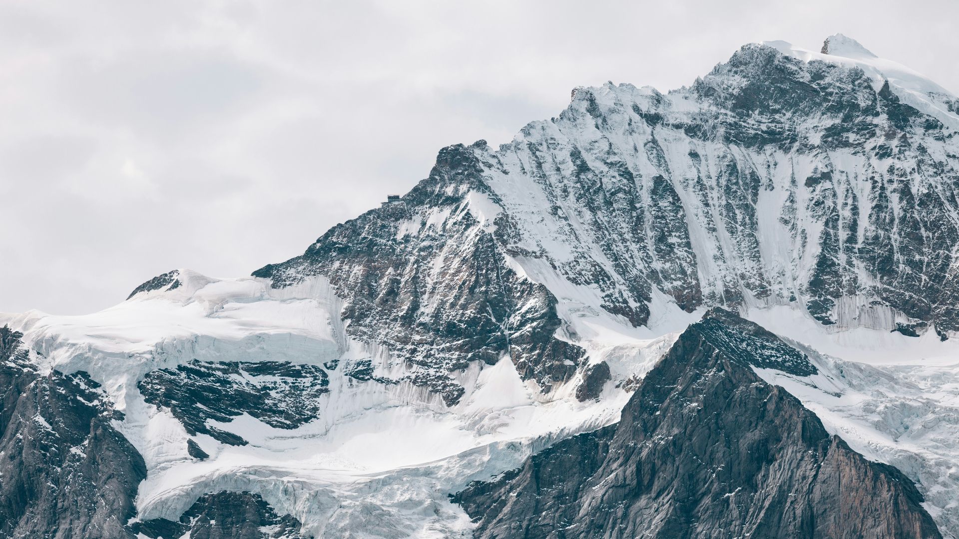 photography of snow covered mountain under cloudy sky