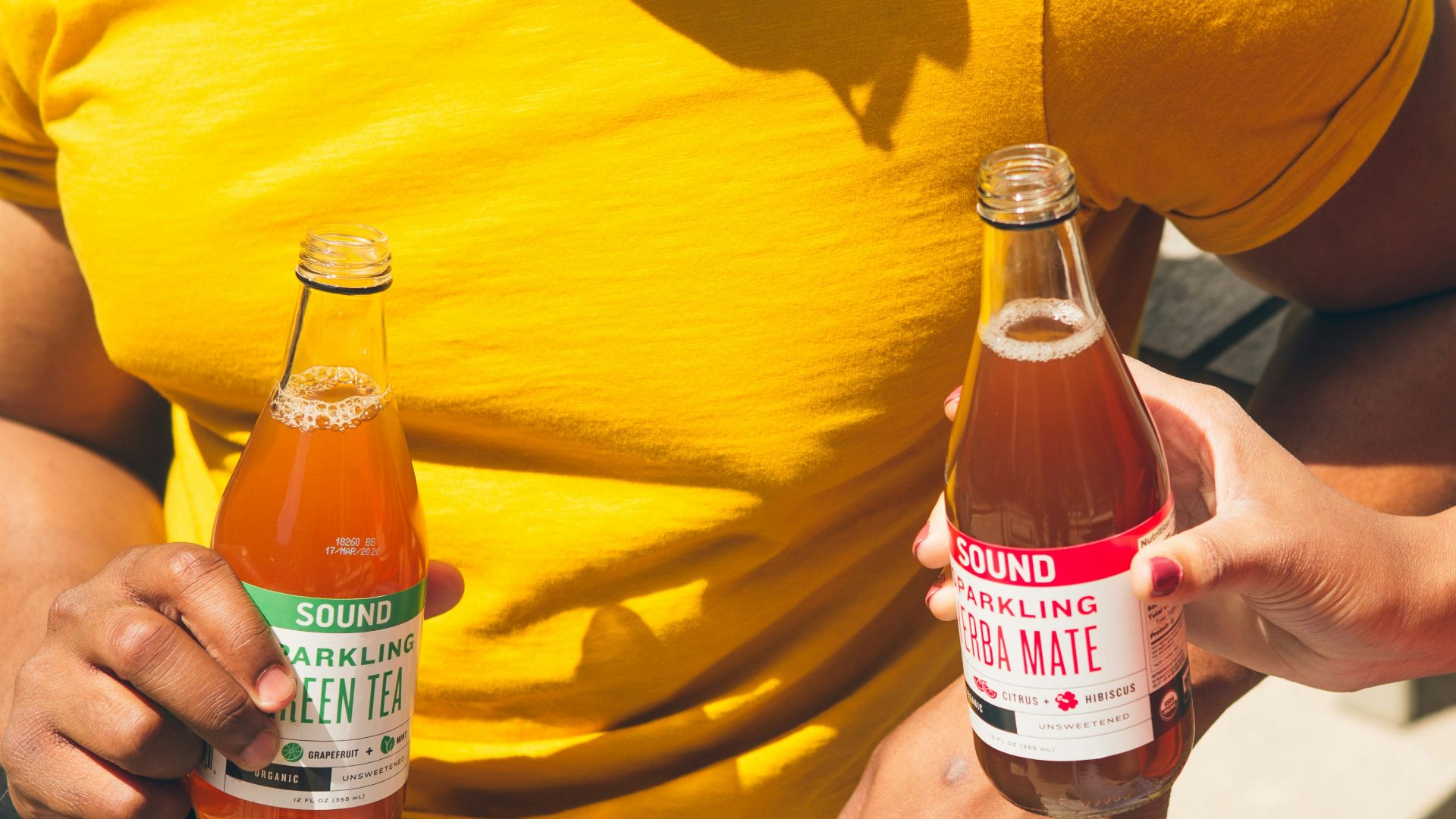 men holding two tea bottles