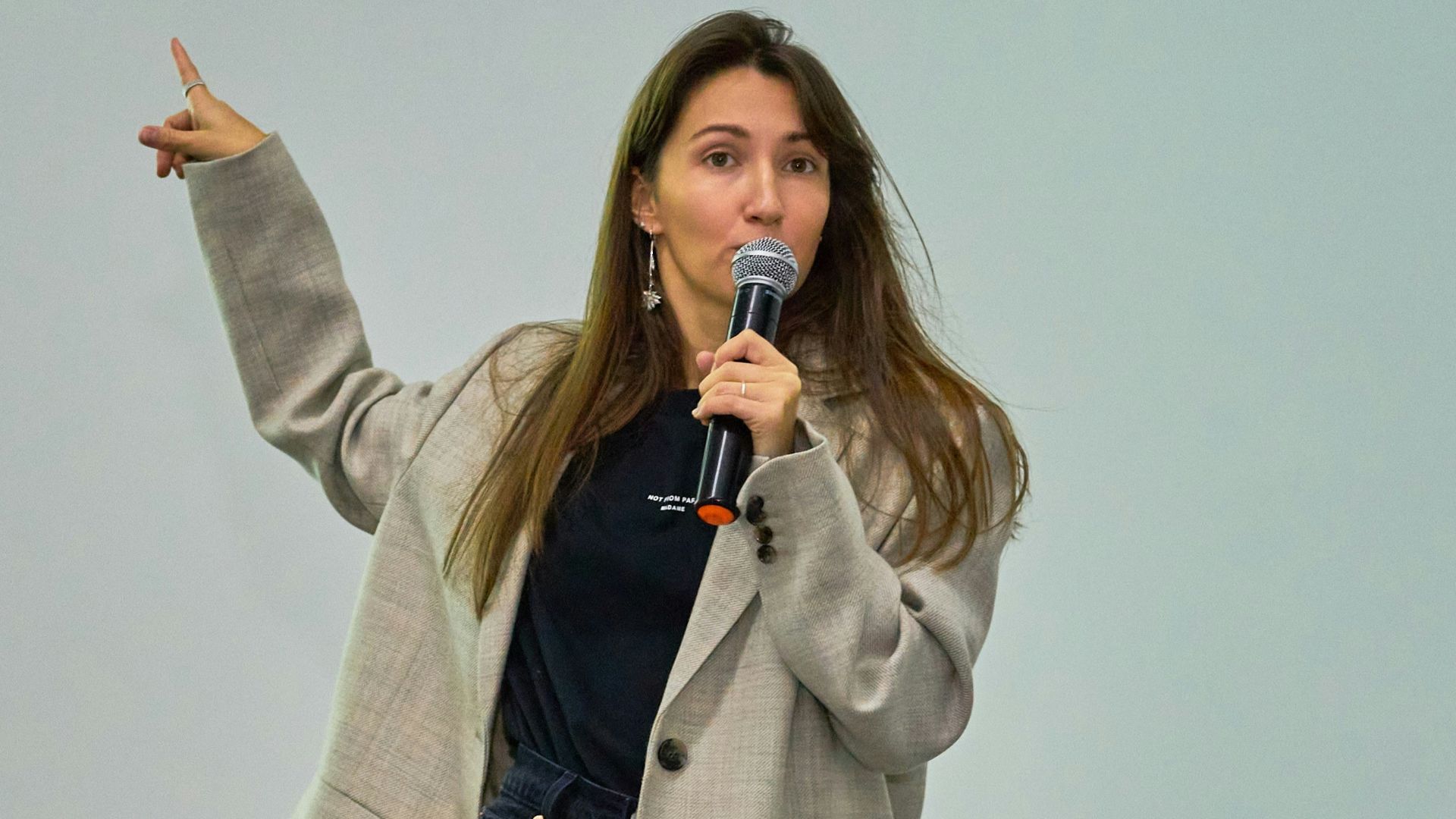 A woman standing in front of a projector screen giving a presentation