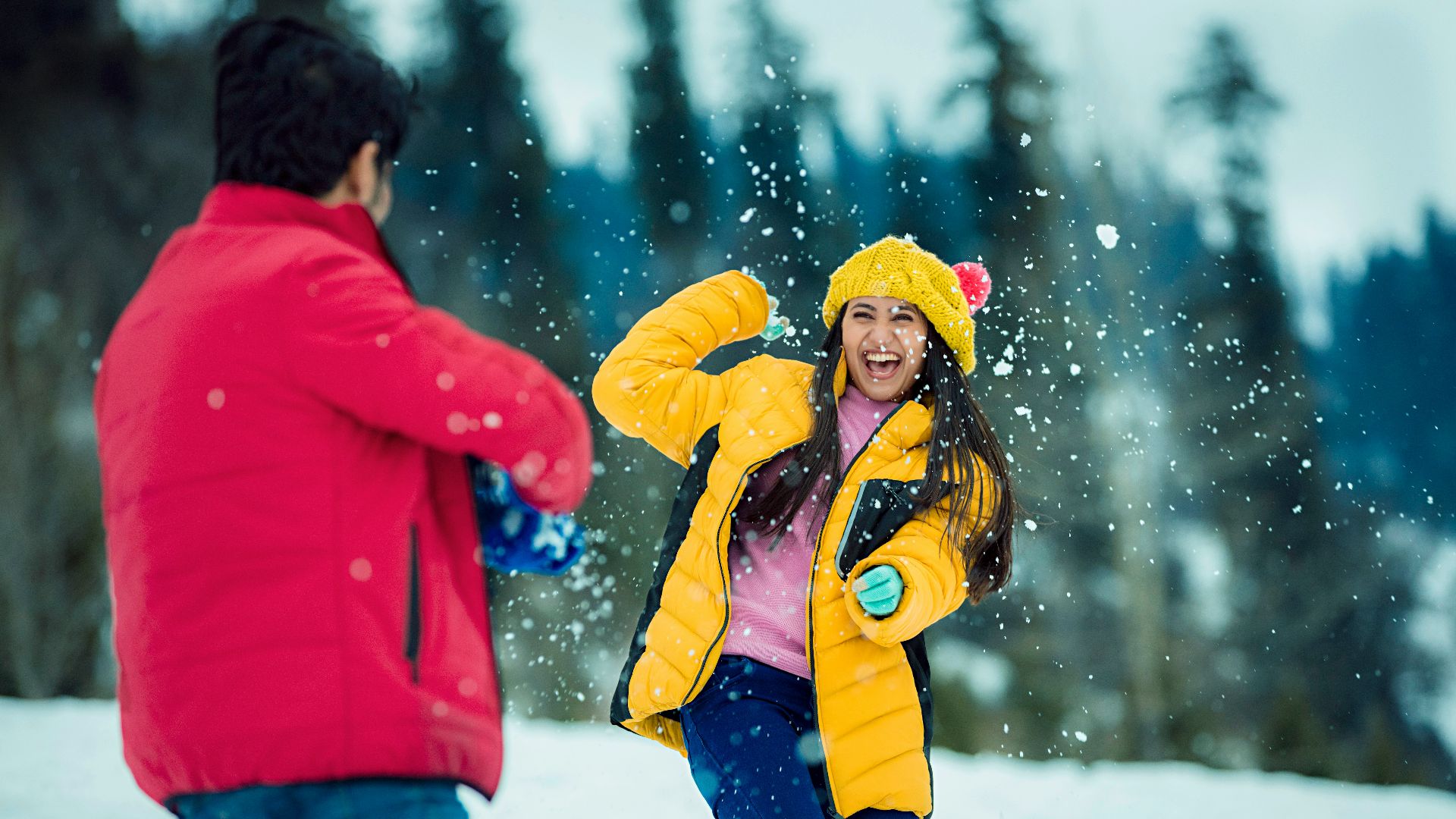 a man and a woman playing in the snow