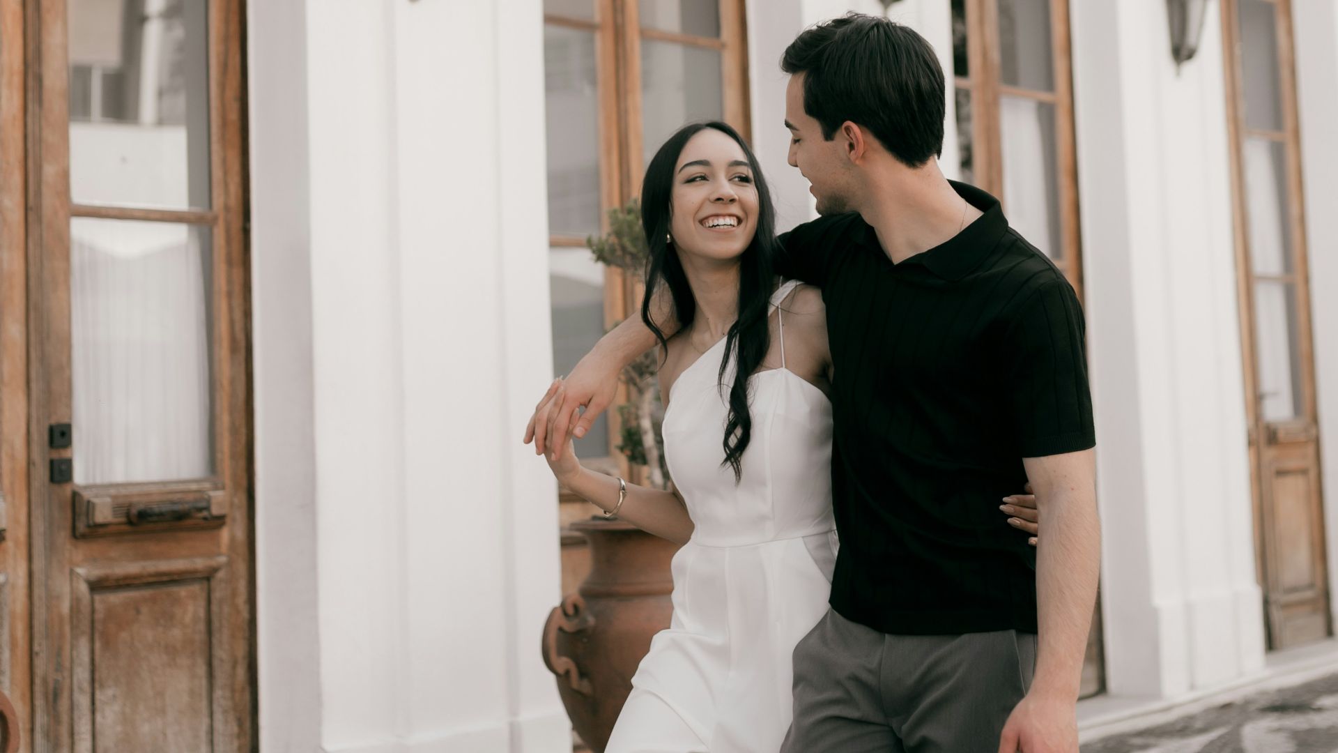 Couple walking arm in arm on cobblestone street