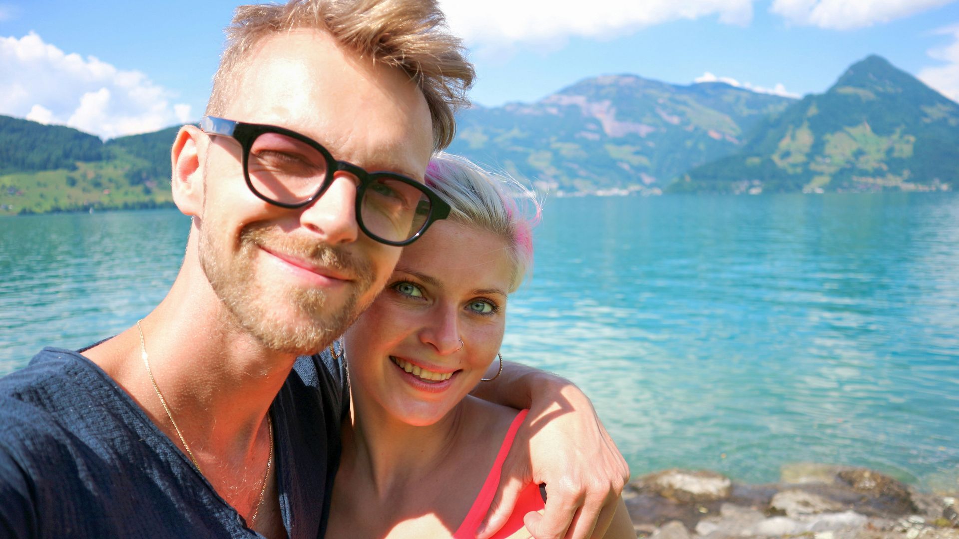 a man and a woman standing next to each other near a body of water