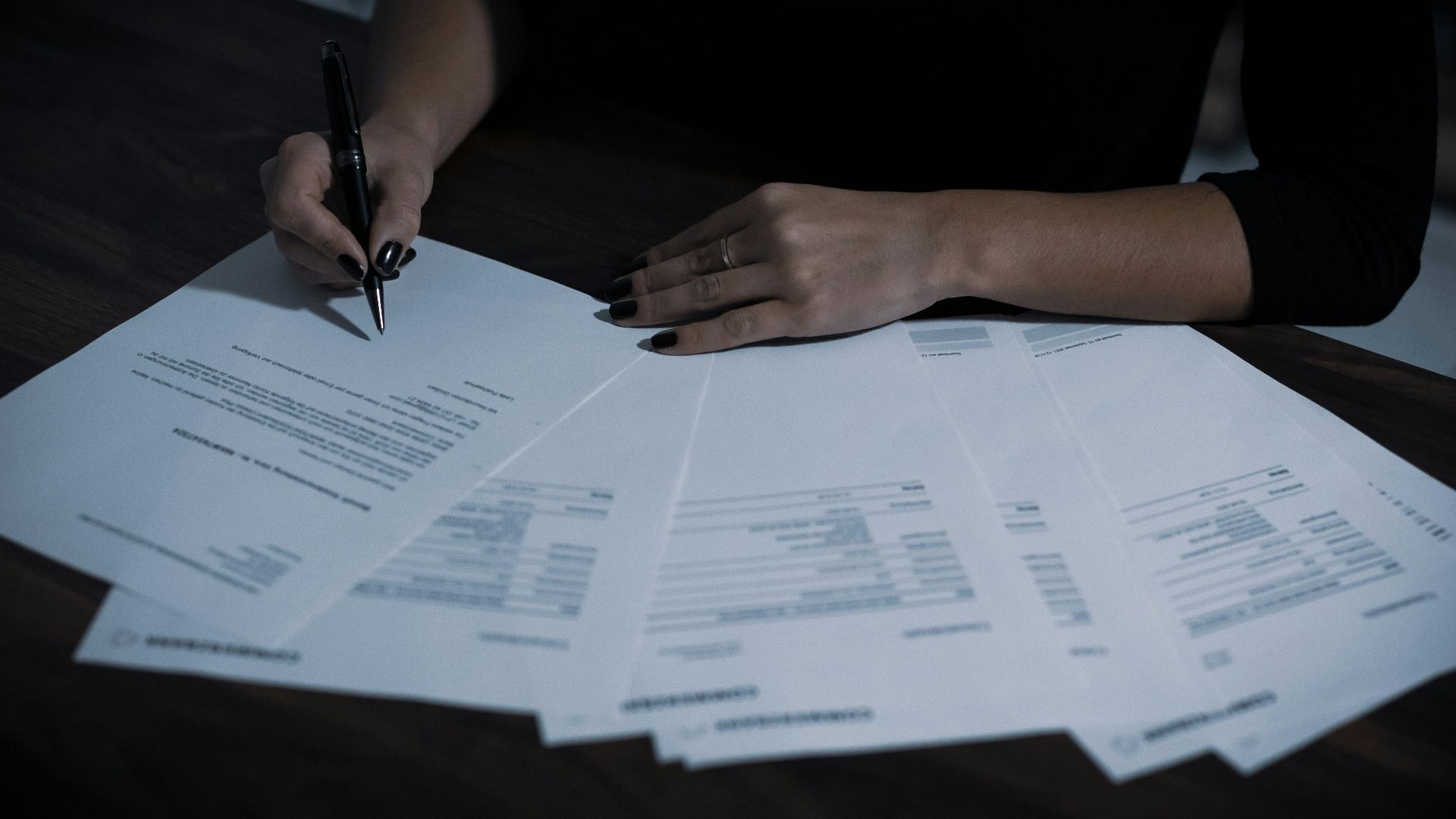a woman sitting at a table with lots of papers