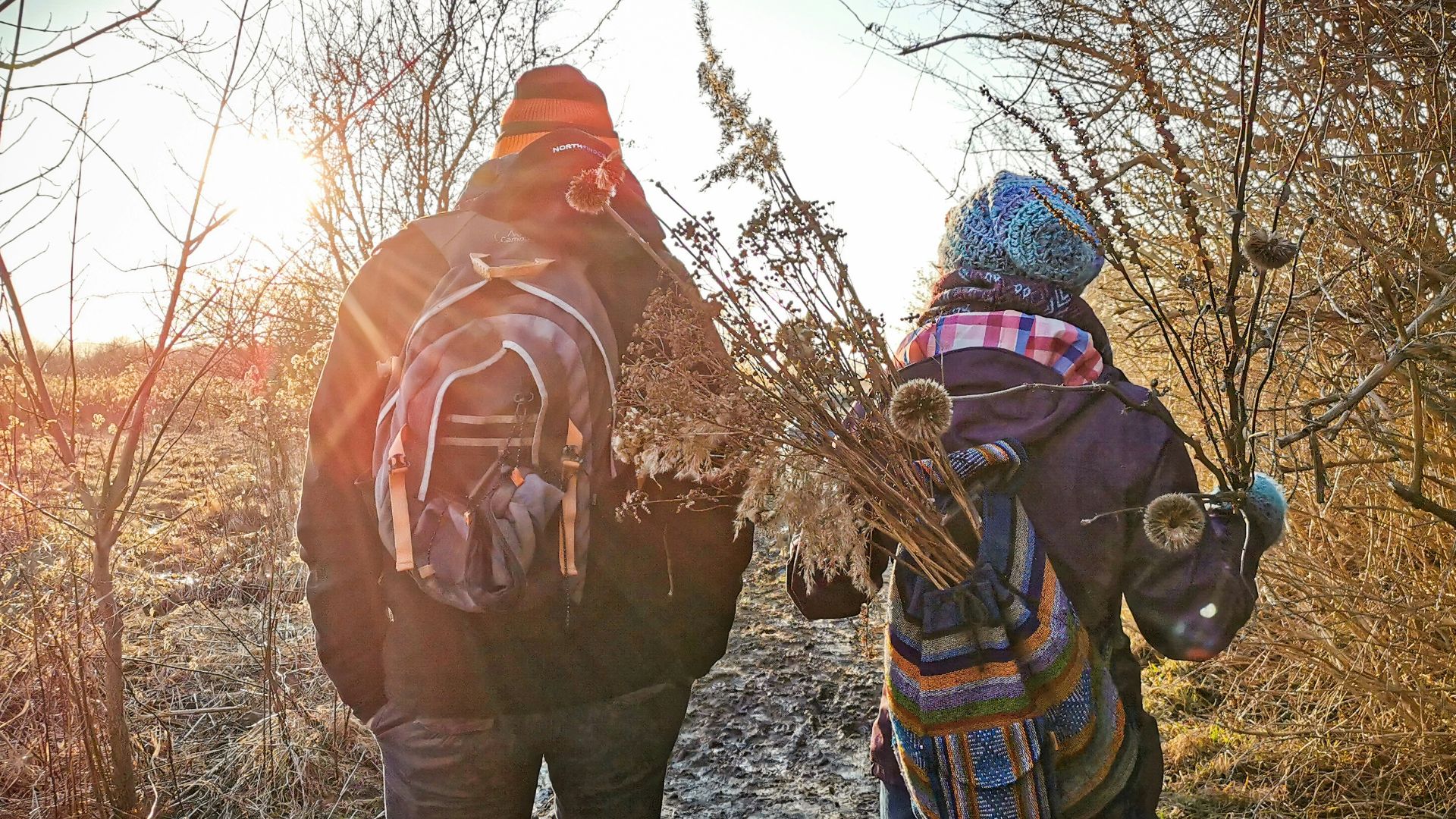 person in orange jacket and blue denim jeans standing on brown grass field during daytime