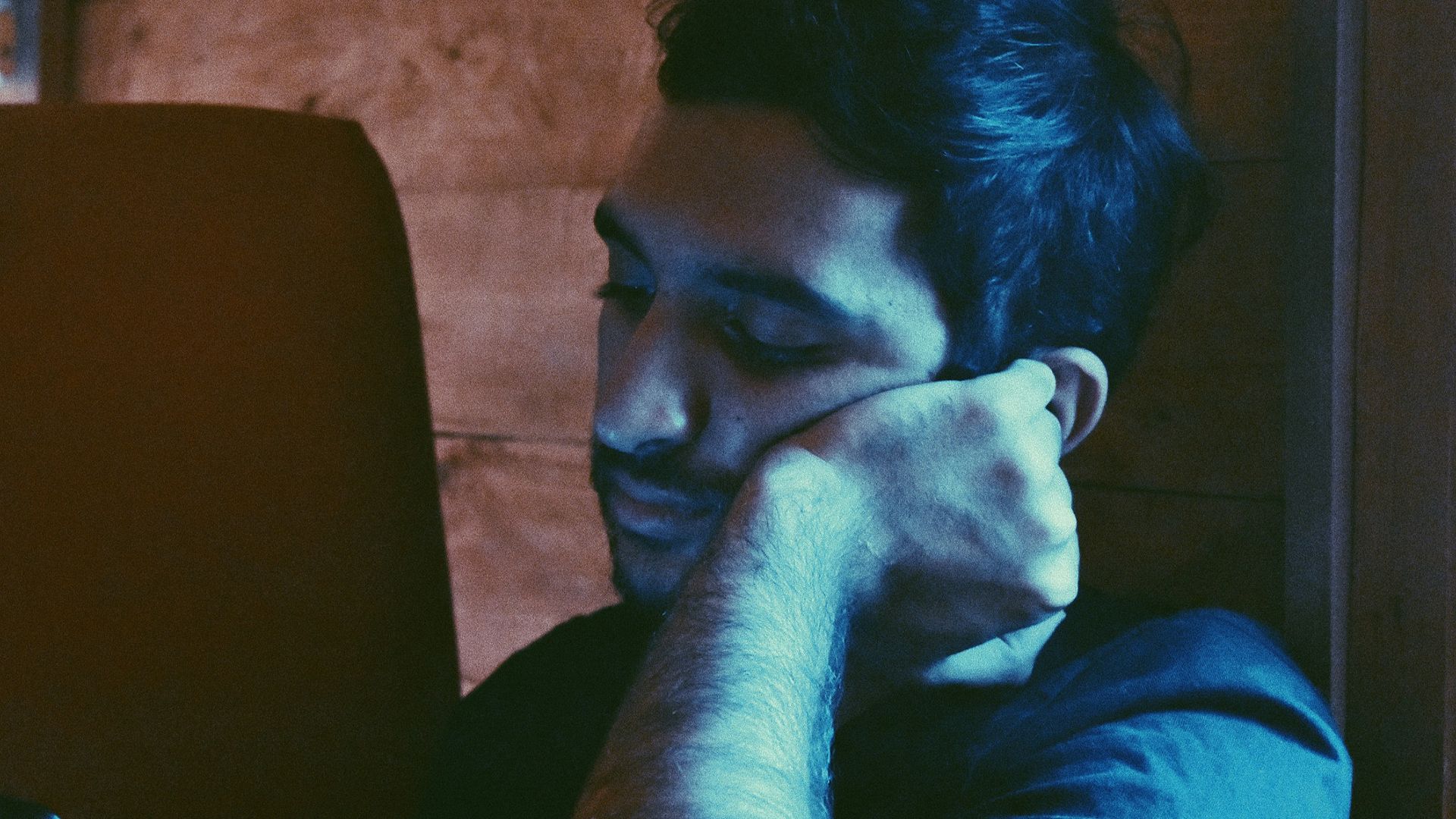 man leaning his face on his left hand