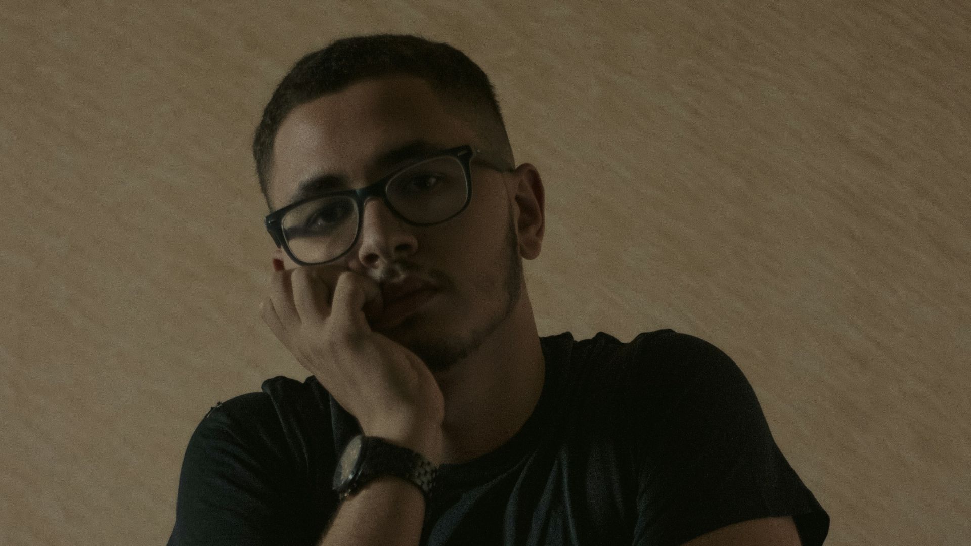 a man sitting at a table with his hand on his chin