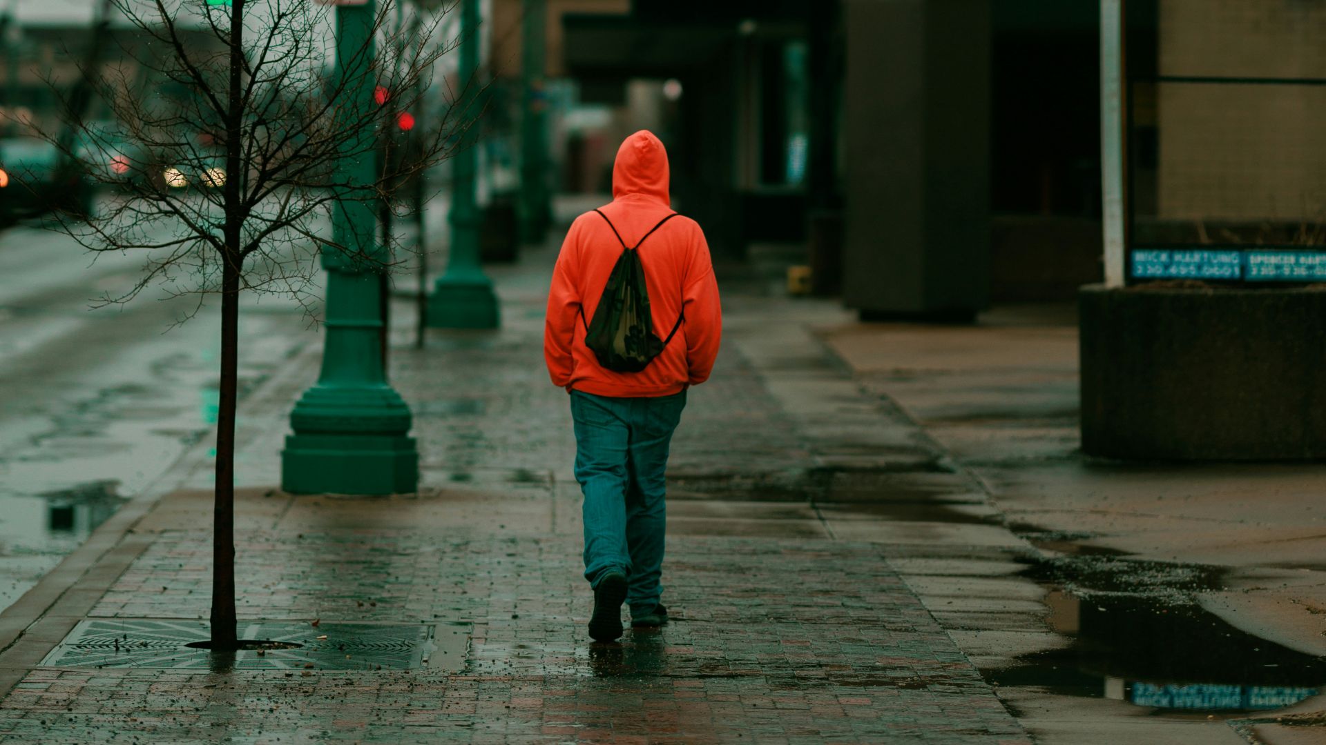 a person in a red jacket is walking down the street