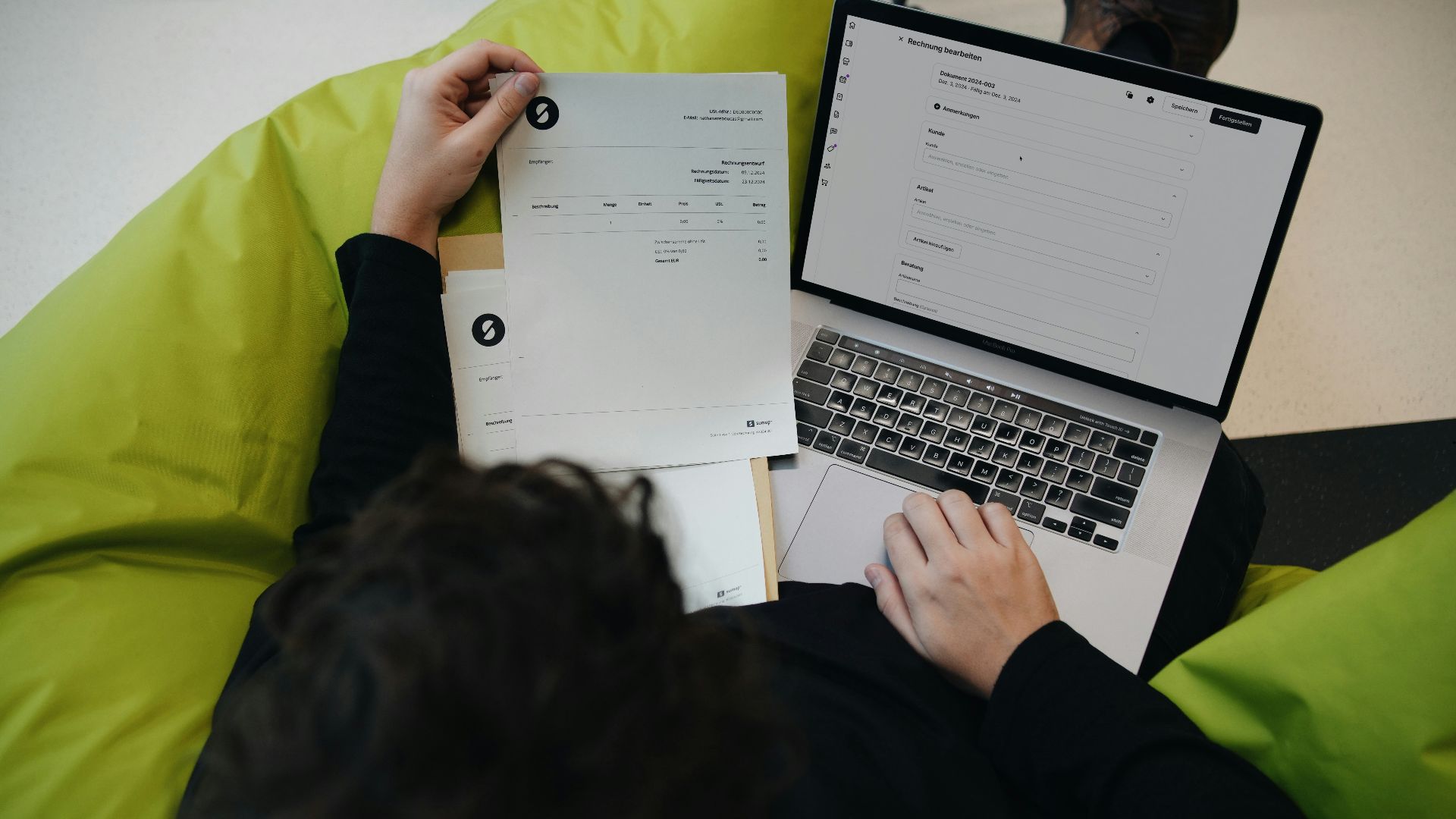 A person sitting on a bean bag chair working on a laptop
