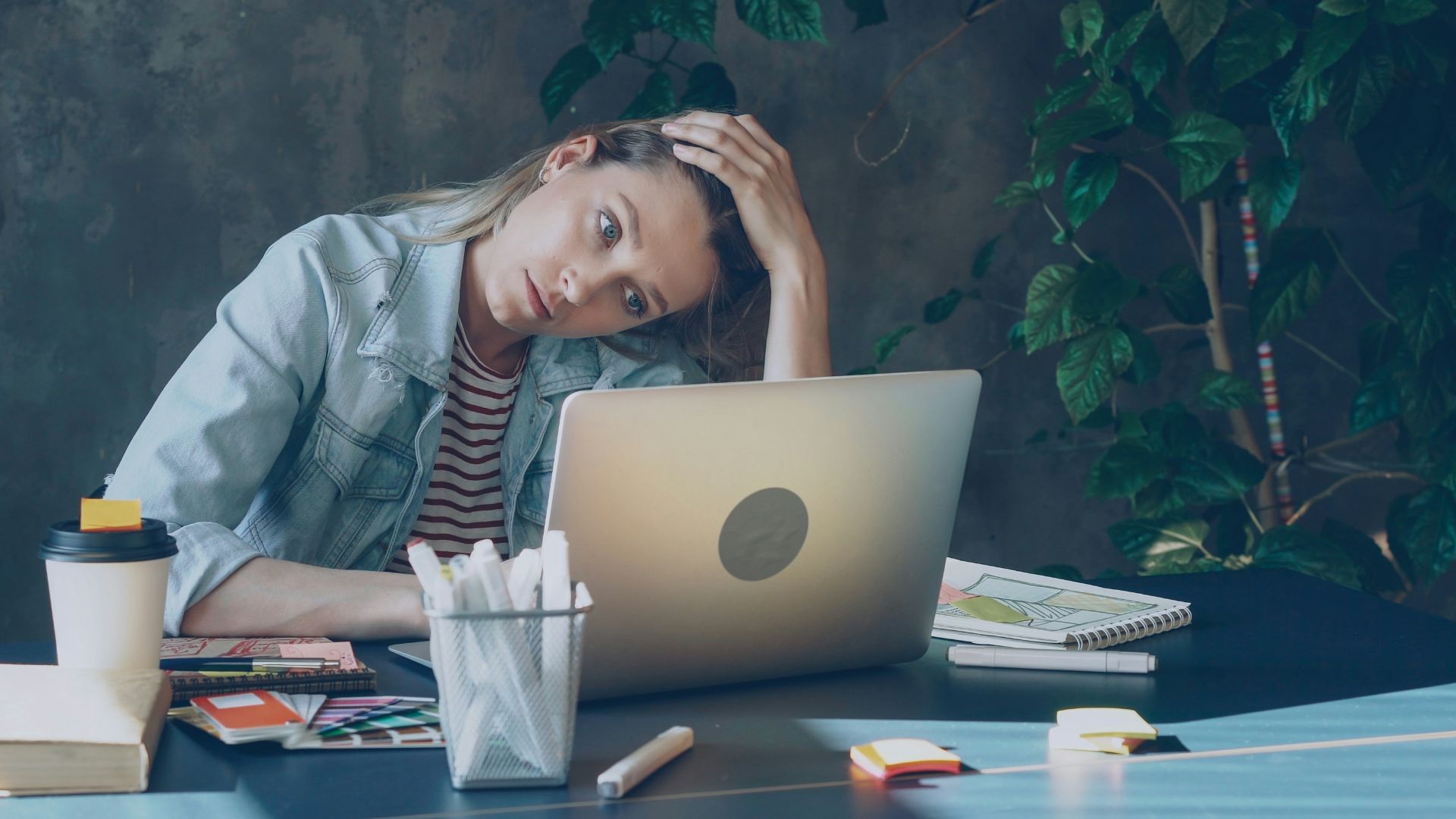 A woman appears stressed while working on laptop.