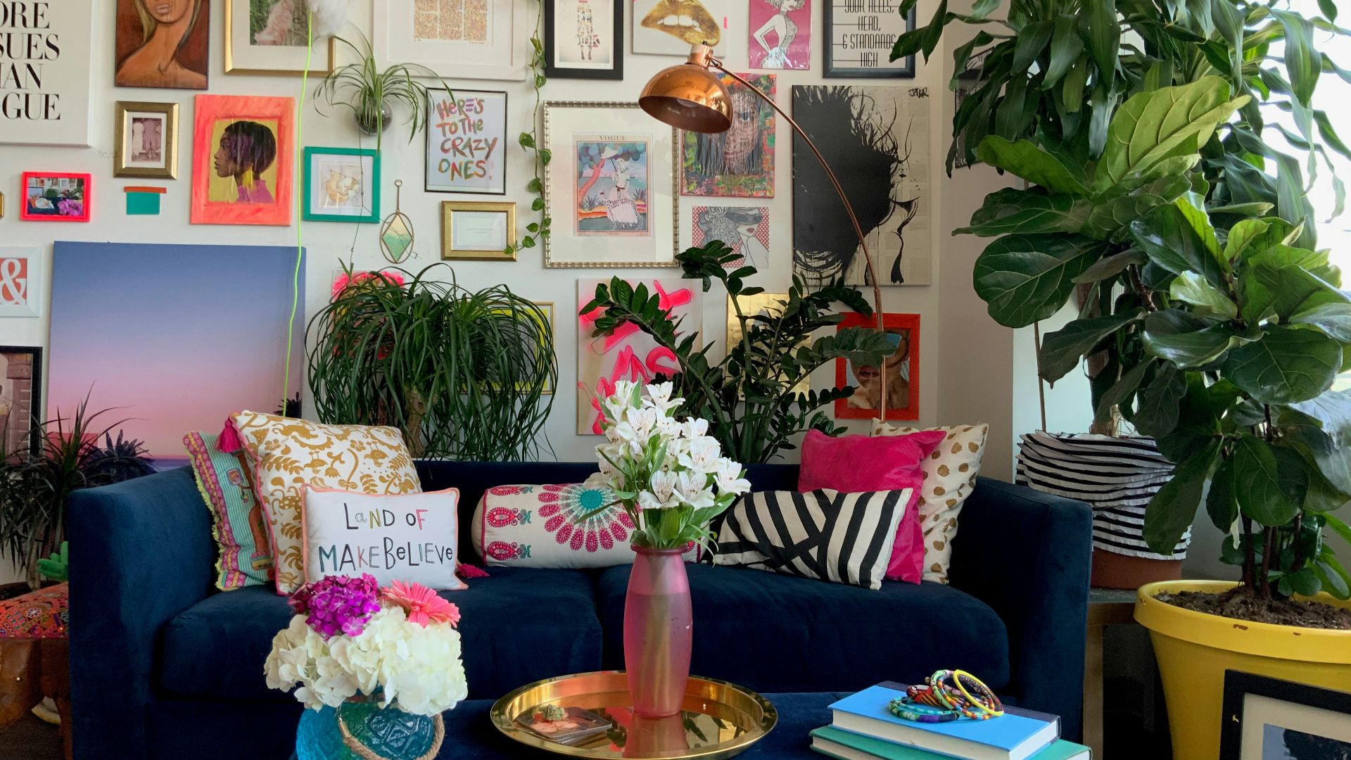 a living room with a blue couch and a vase with flowers
