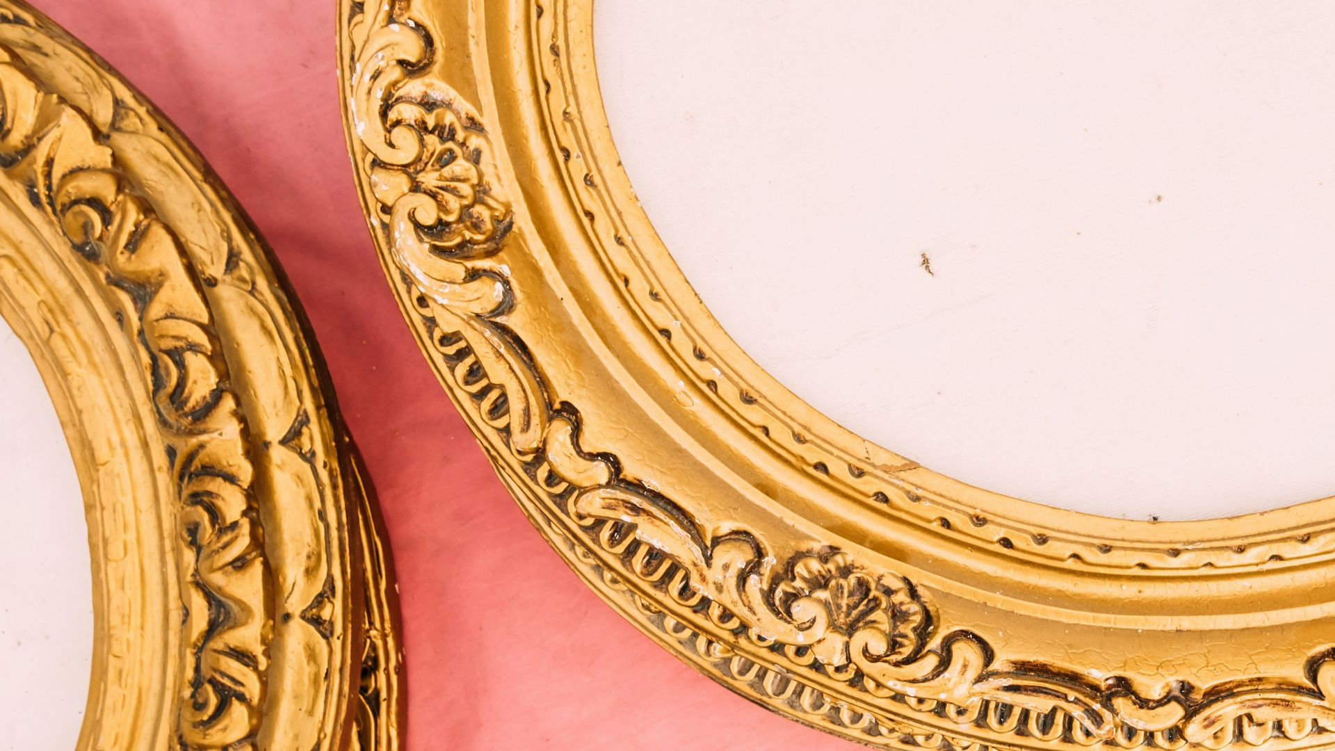 a close up of two gold framed mirrors