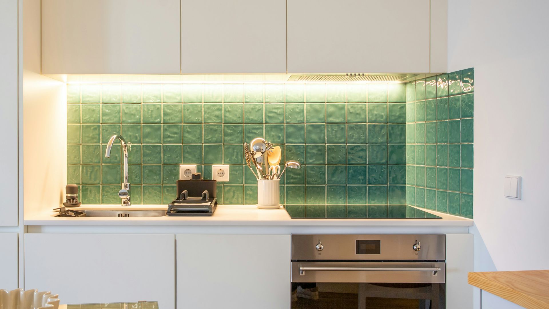 a kitchen with a sink, stove, microwave and toaster oven