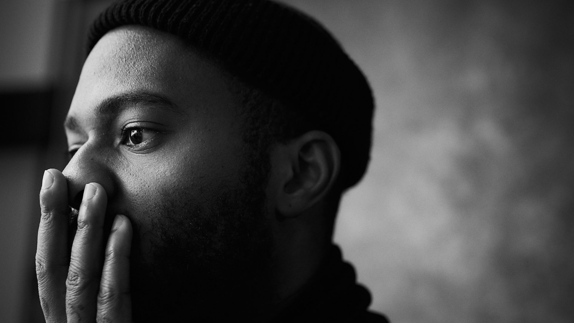 man in knit cap grayscale photo