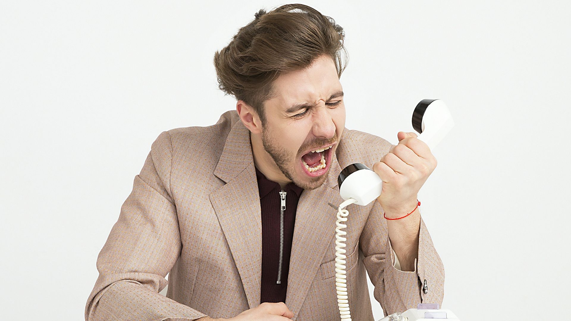 man holding telephone screaming