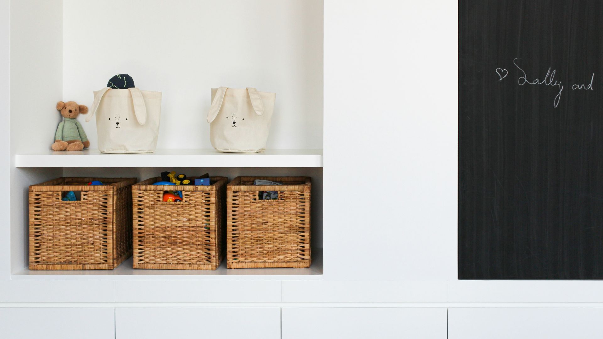 a shelf with baskets and a teddy bear on it