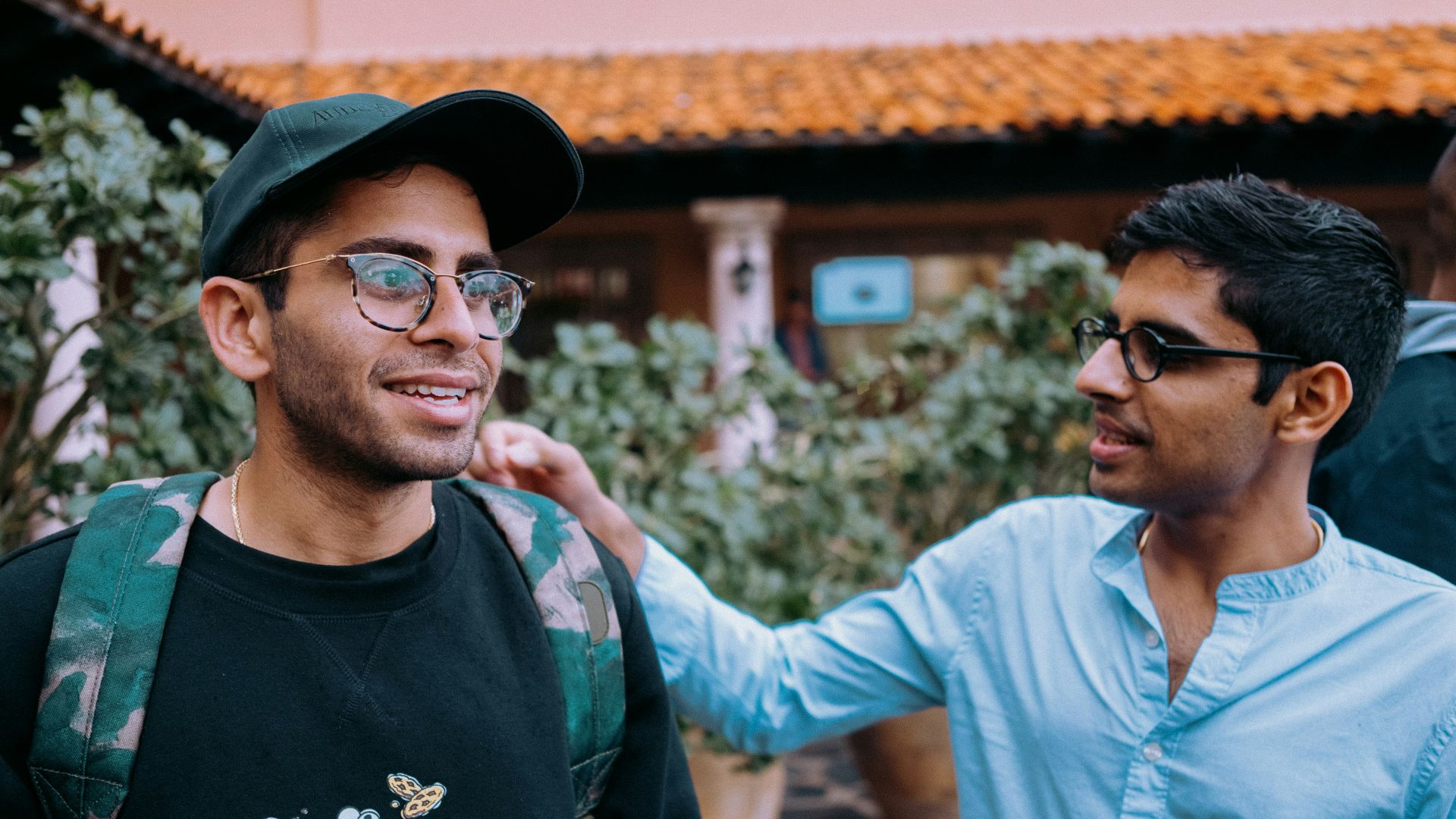 man in black crew neck shirt wearing black framed eyeglasses and black hat