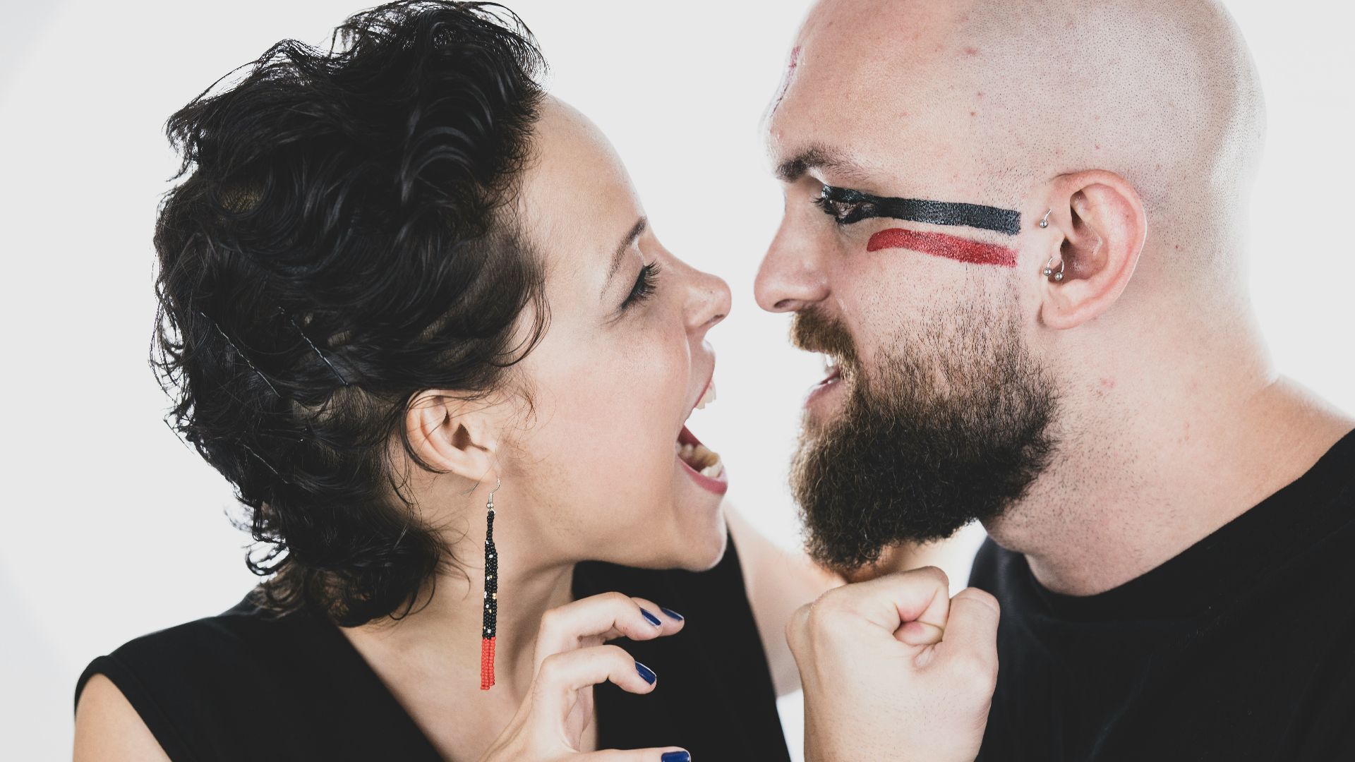 man in black shirt holding black smartphone beside woman in black shirt