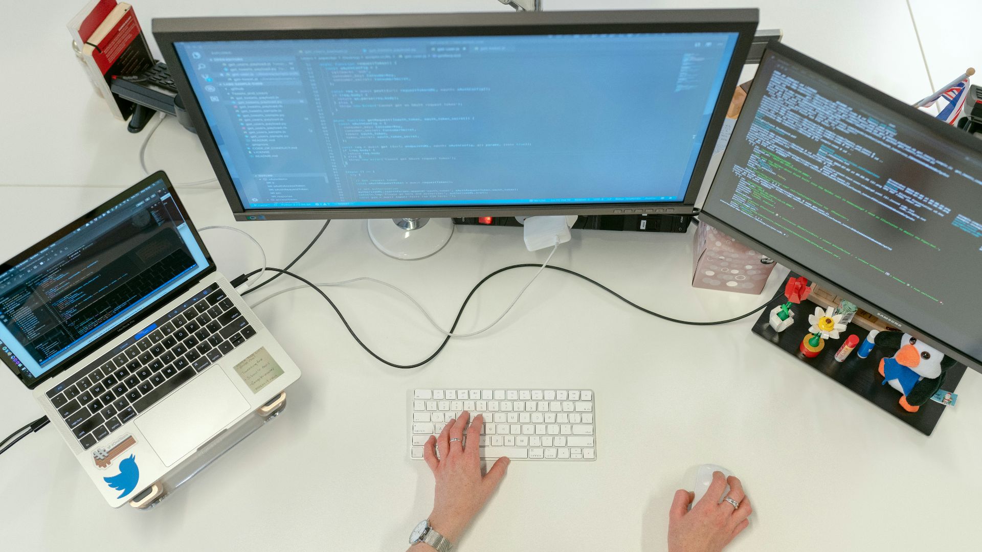 person using macbook pro on white table