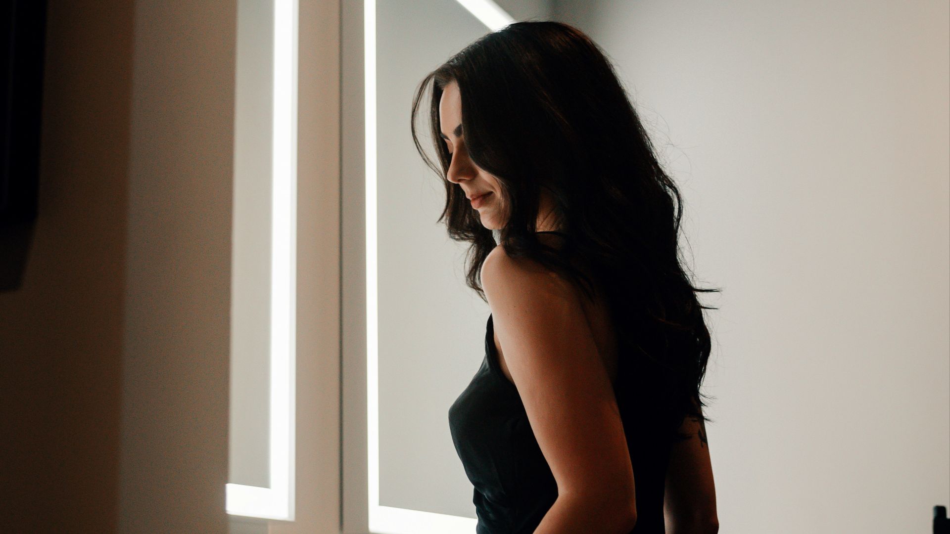 a woman standing in front of a mirror in a bathroom