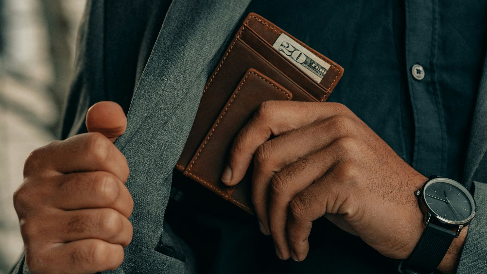 a man holding a wallet and a watch