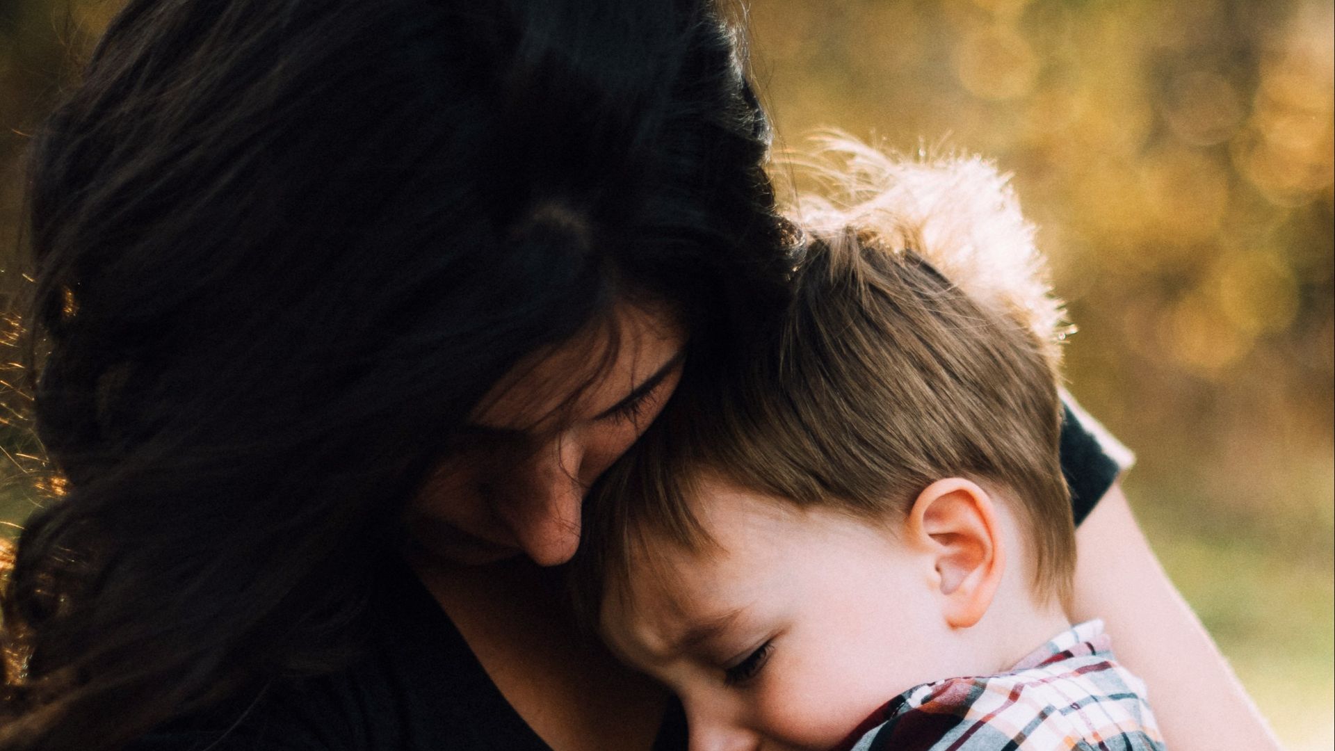 woman hugging boy on her lap