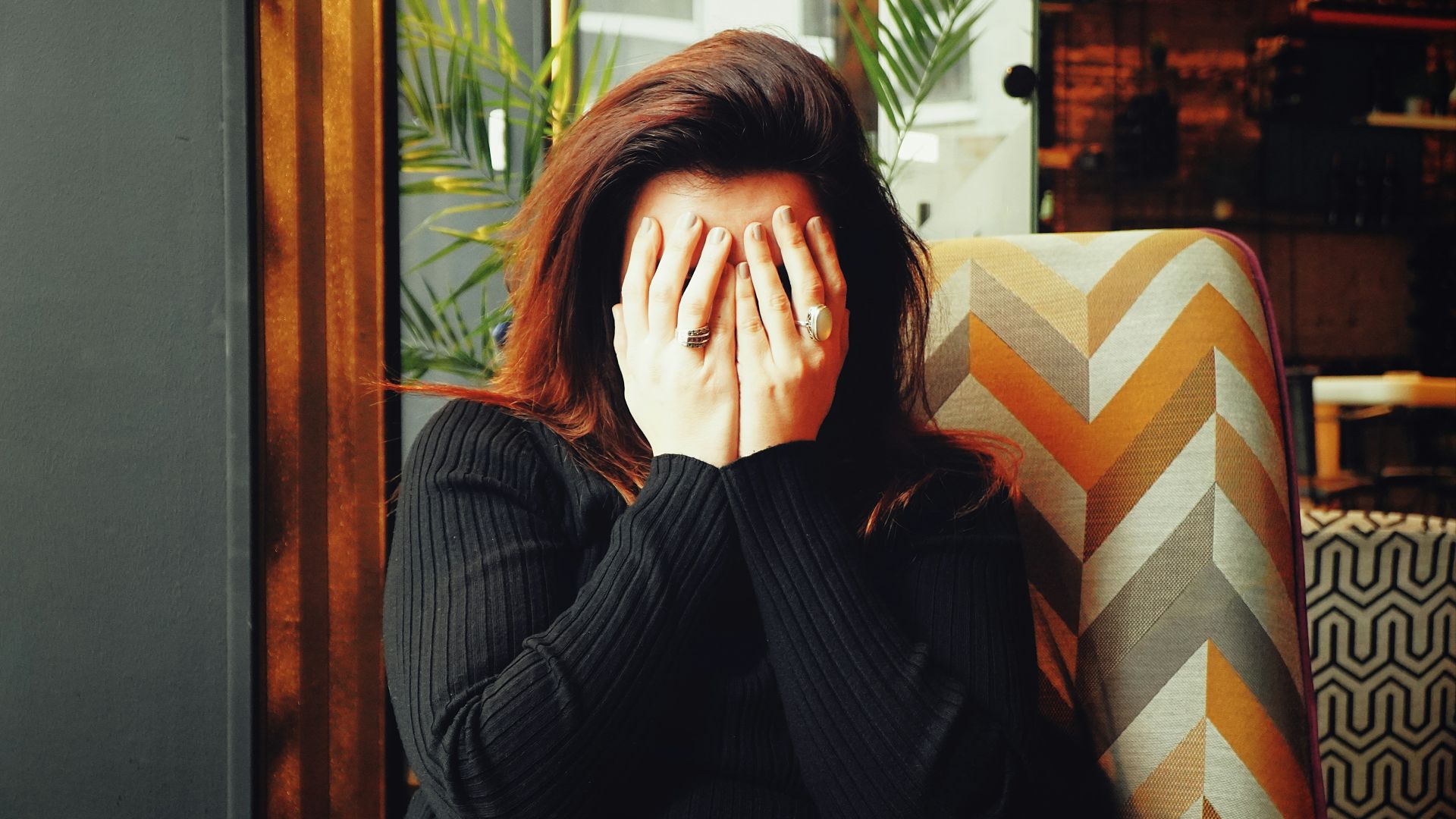 woman in black long sleeve shirt covering her face
