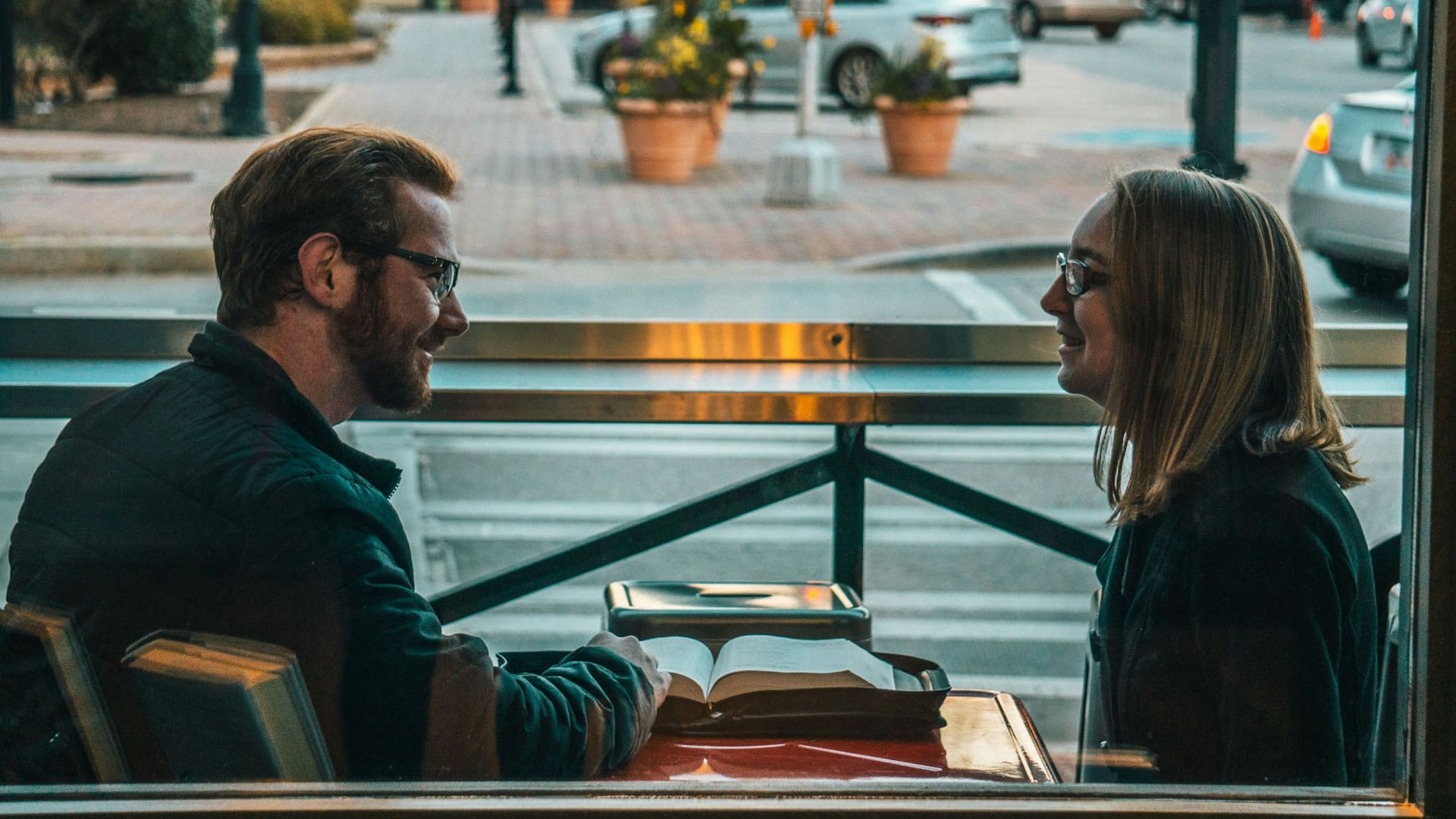 man and woman sitting while talking during daytime