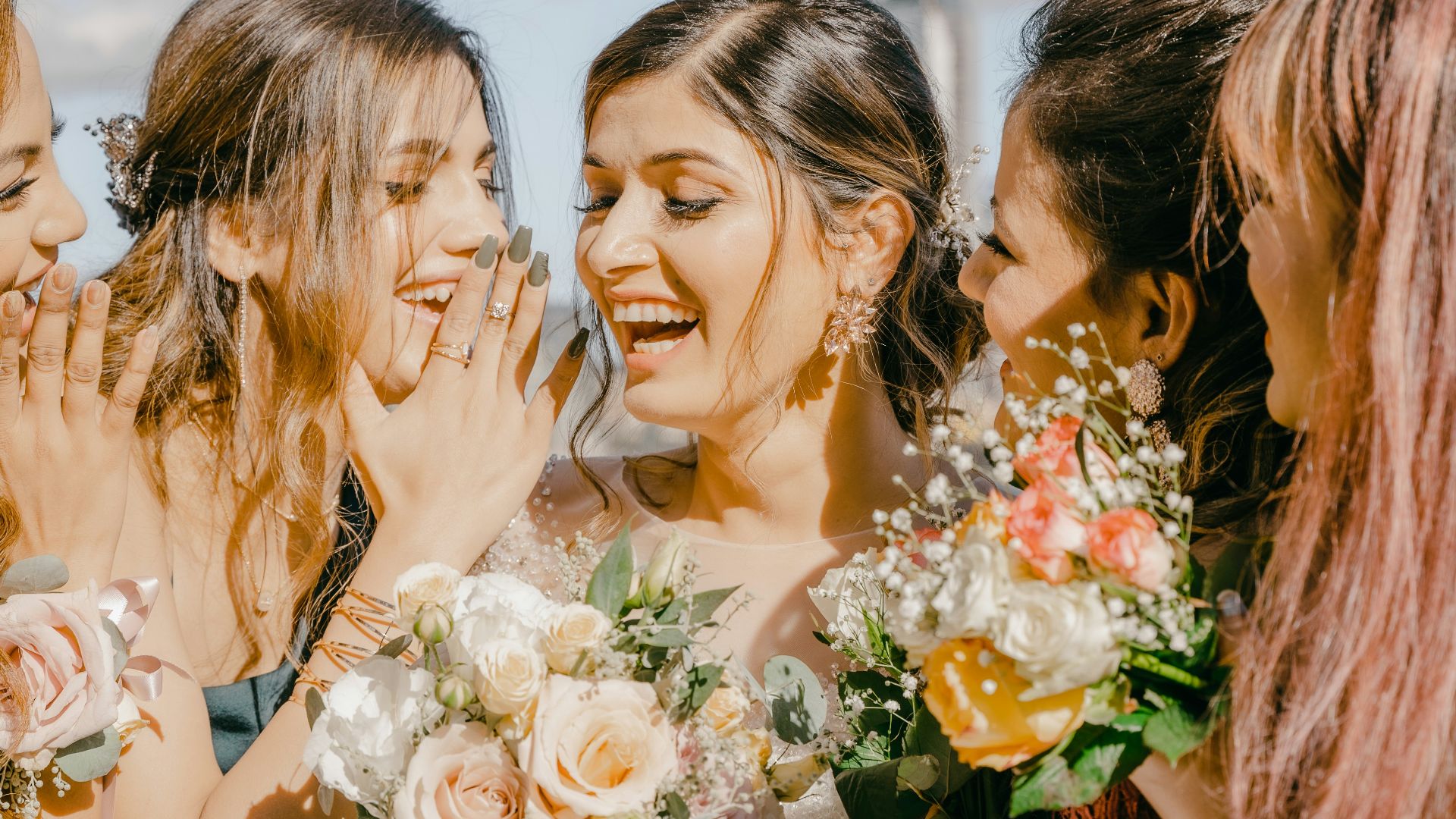 3 women in white floral dress holding bouquet of flowers