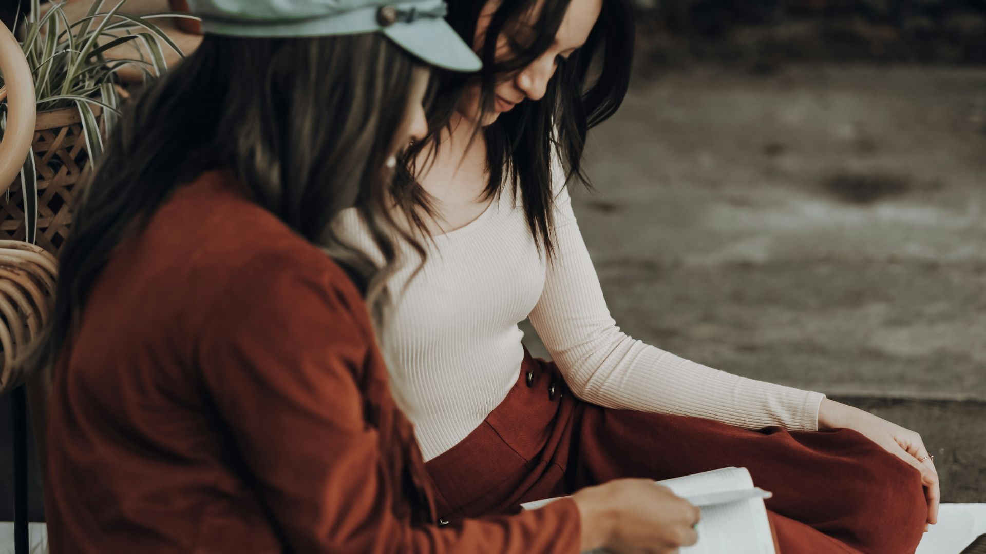 woman in white tank top and orange jacket holding white printer paper