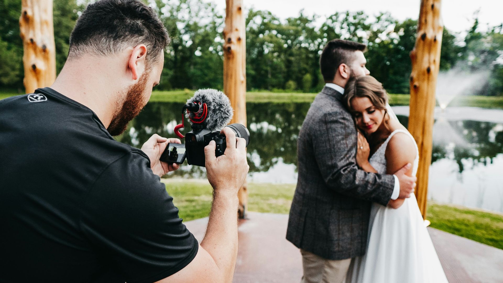 man in black t-shirt holding black dslr camera