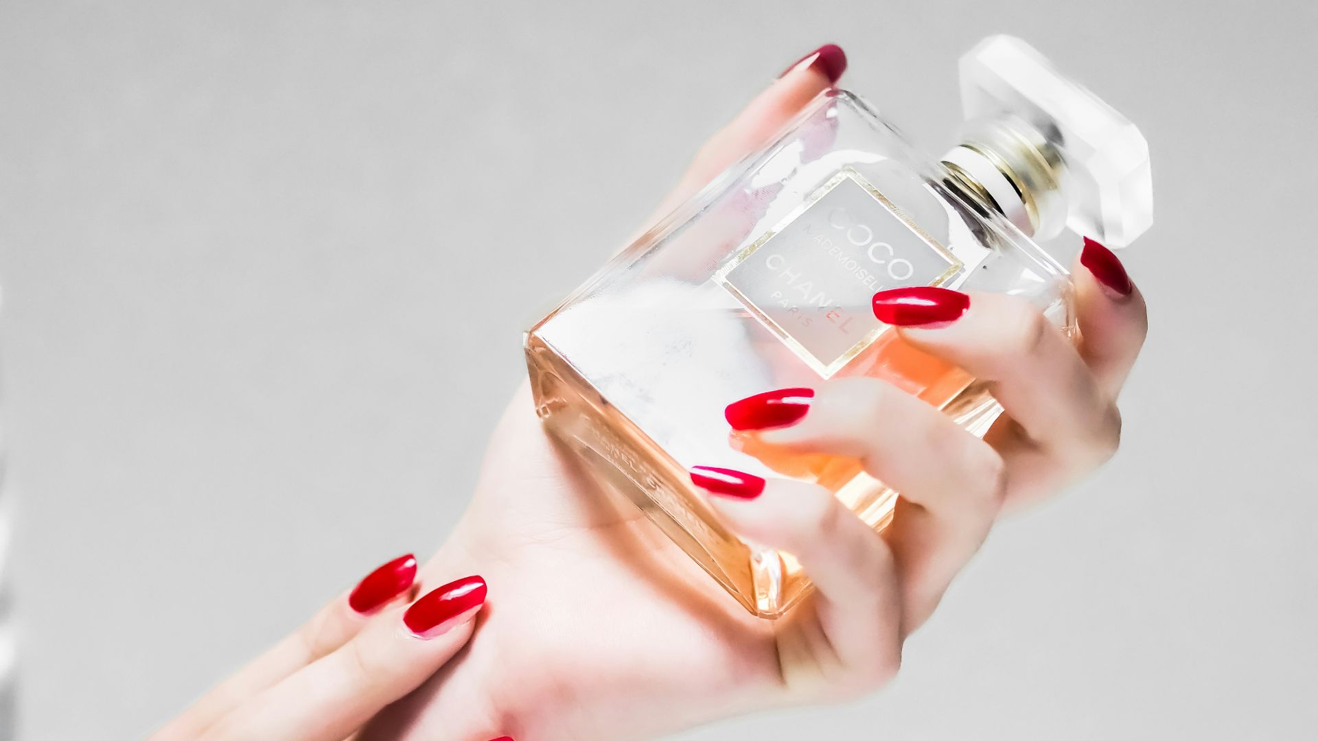 person holding clear glass bottle