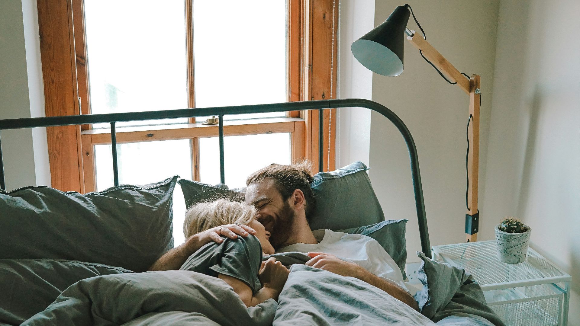 man kissing woman on her forehead