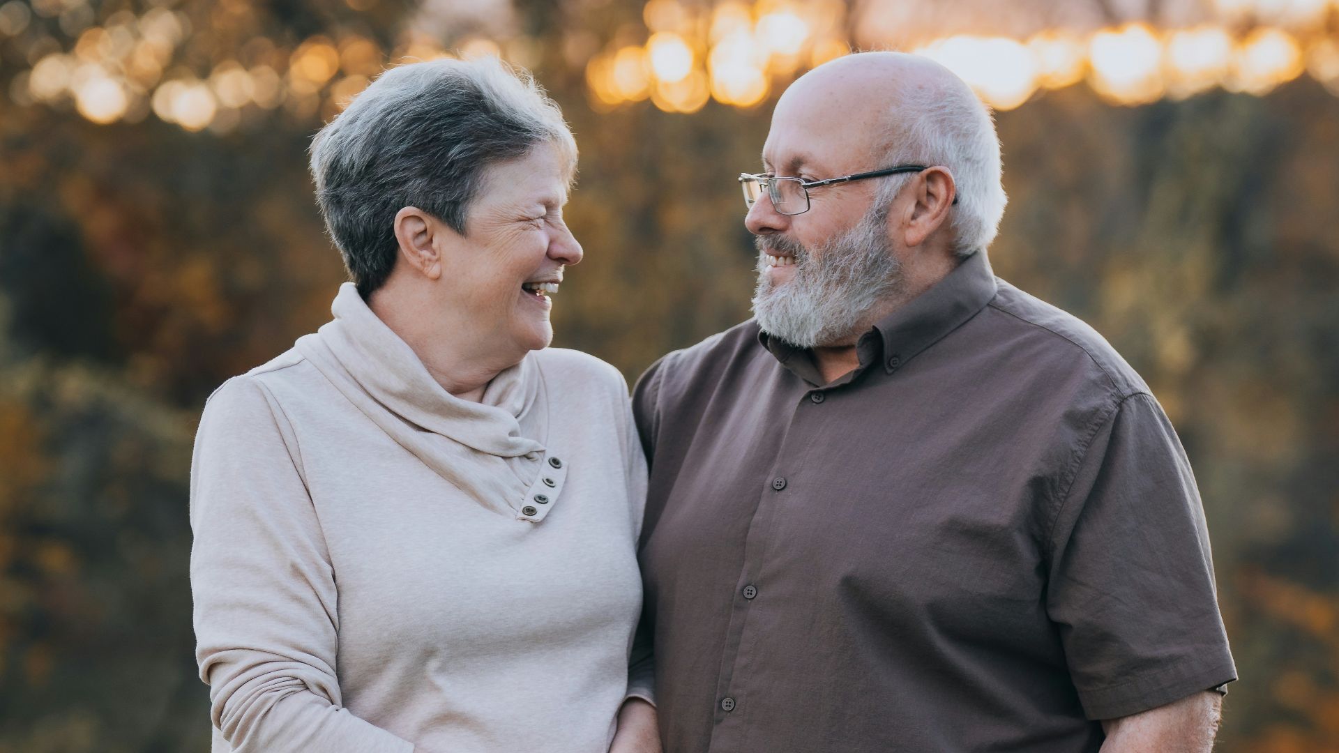 A man and woman standing next to each other in a field