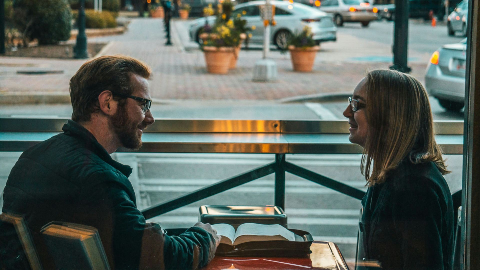 man and woman sitting while talking during daytime