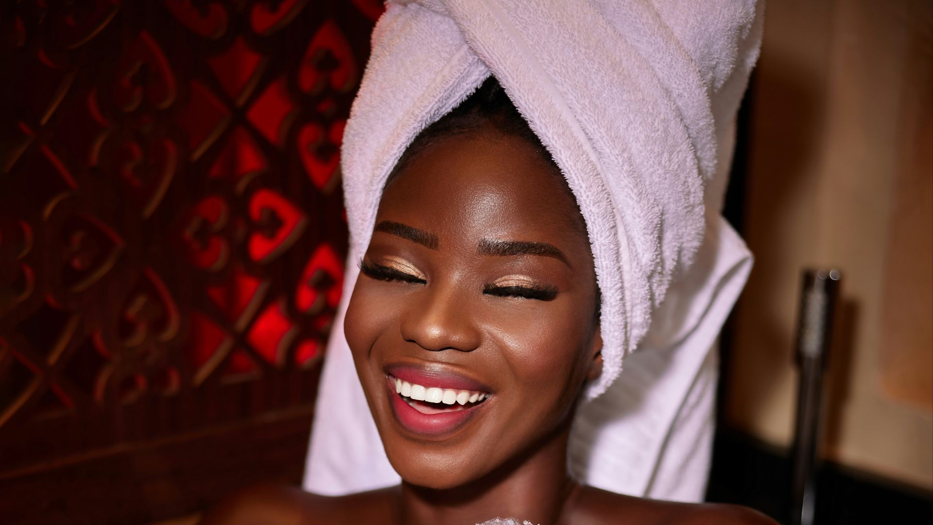 a woman in a bathtub with a white towel on her head