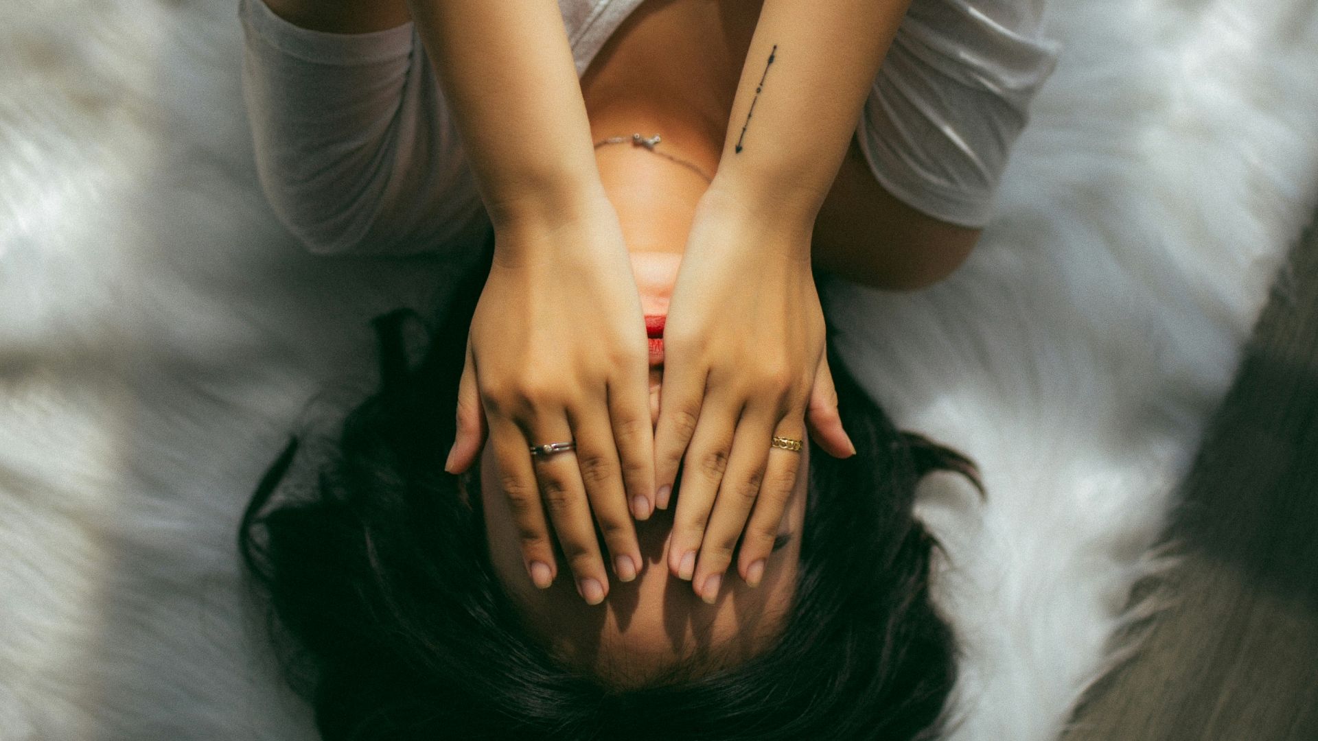 a woman holds her hands over her face