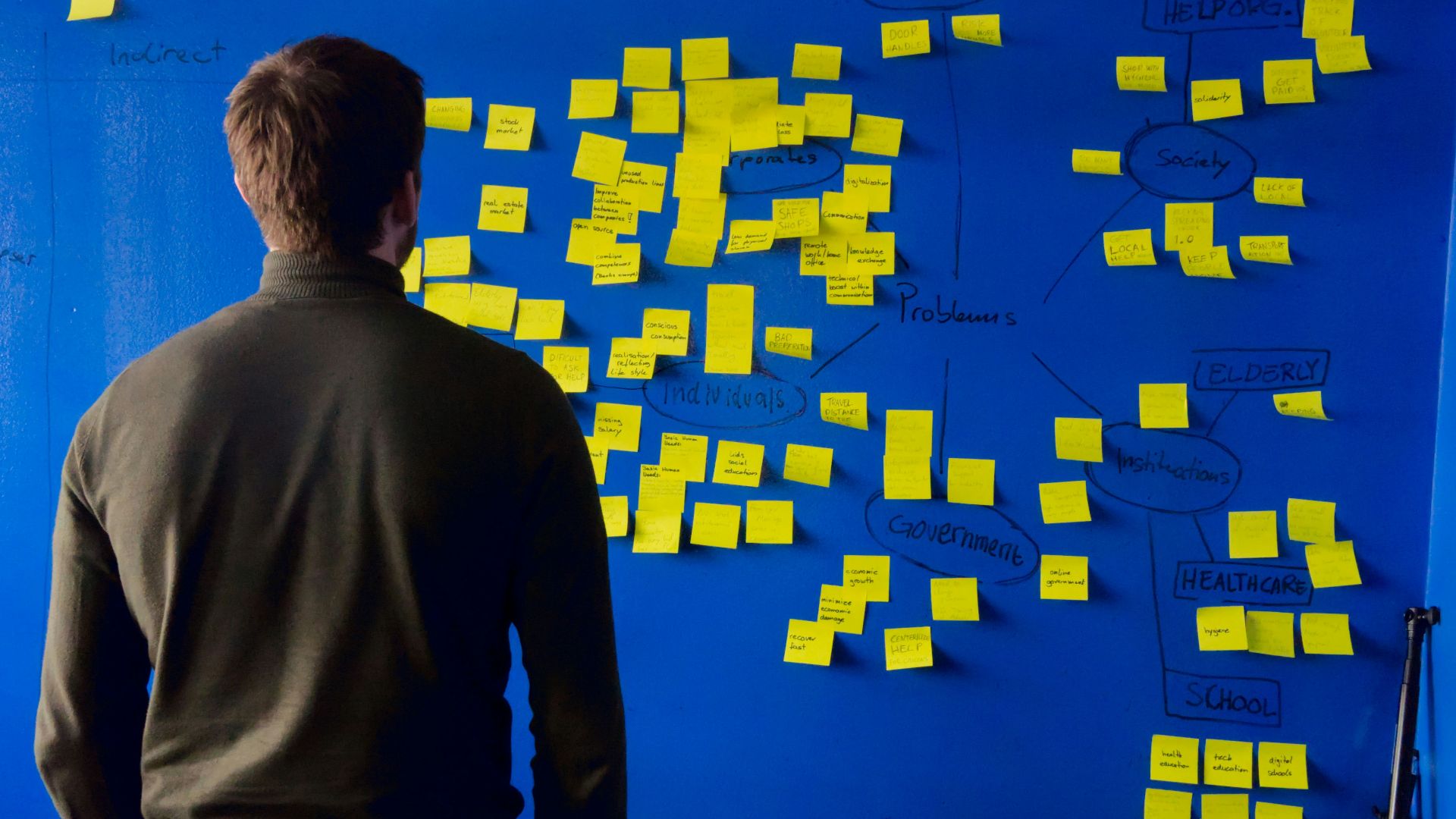 man in gray long sleeve shirt standing in front of blue and yellow puzzle mat