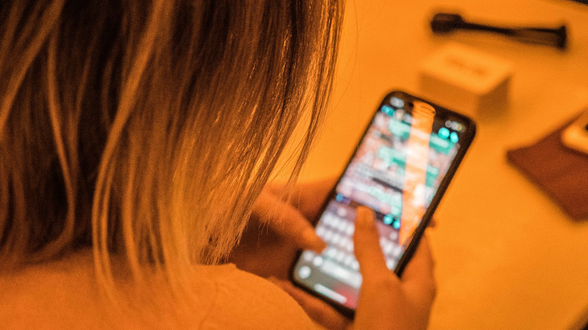 woman in white shirt holding black iphone 4